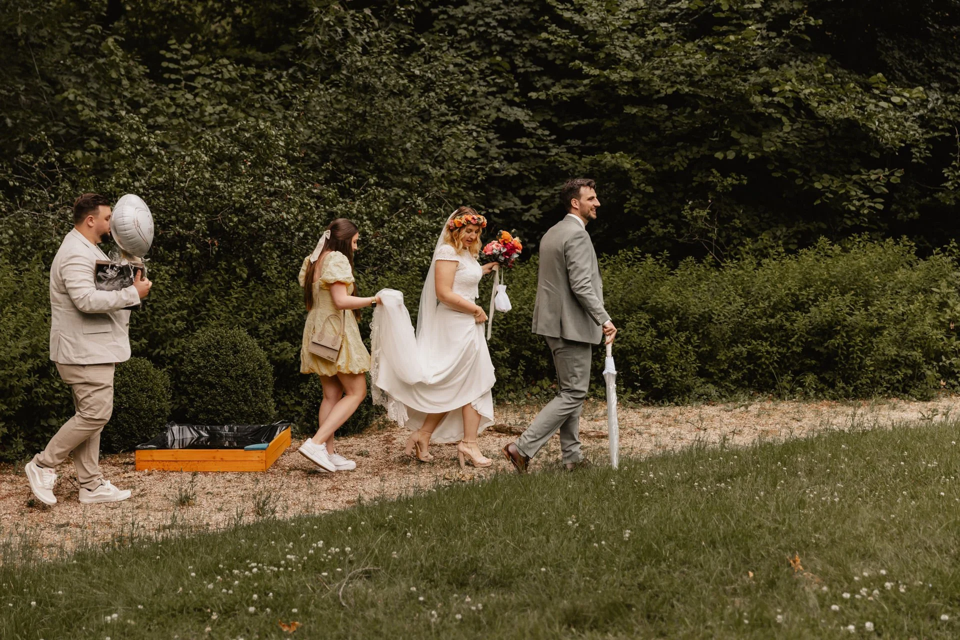 Brautpaar läuft mit Brautjungfer und Trauzeugen durch den Garten bei ihrer Hochzeit in Lüneburg