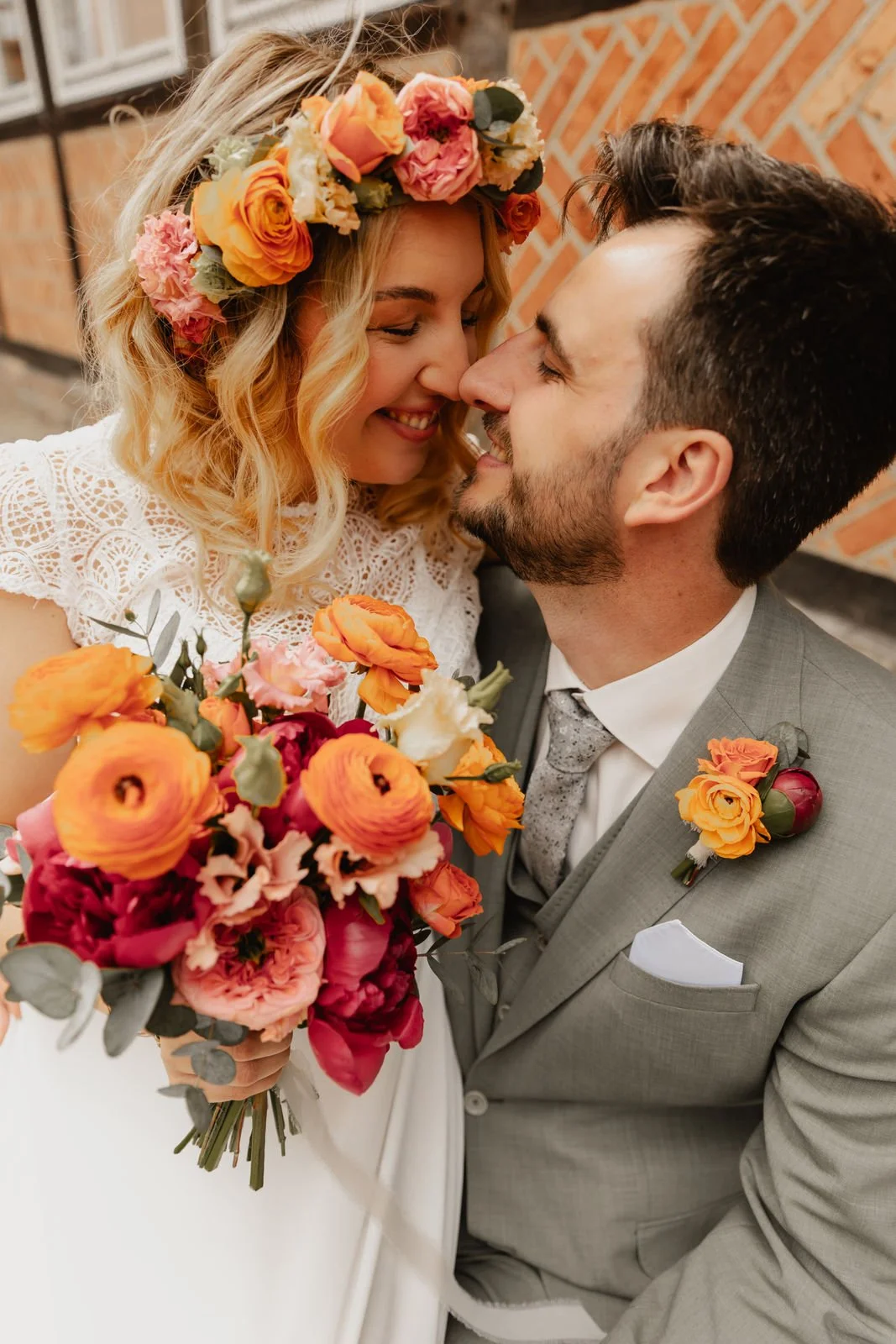 Fröhliches Brautpaar mit Blumenstrauß und Blumenkranz bei ihrer Hochzeit in Lüneburg