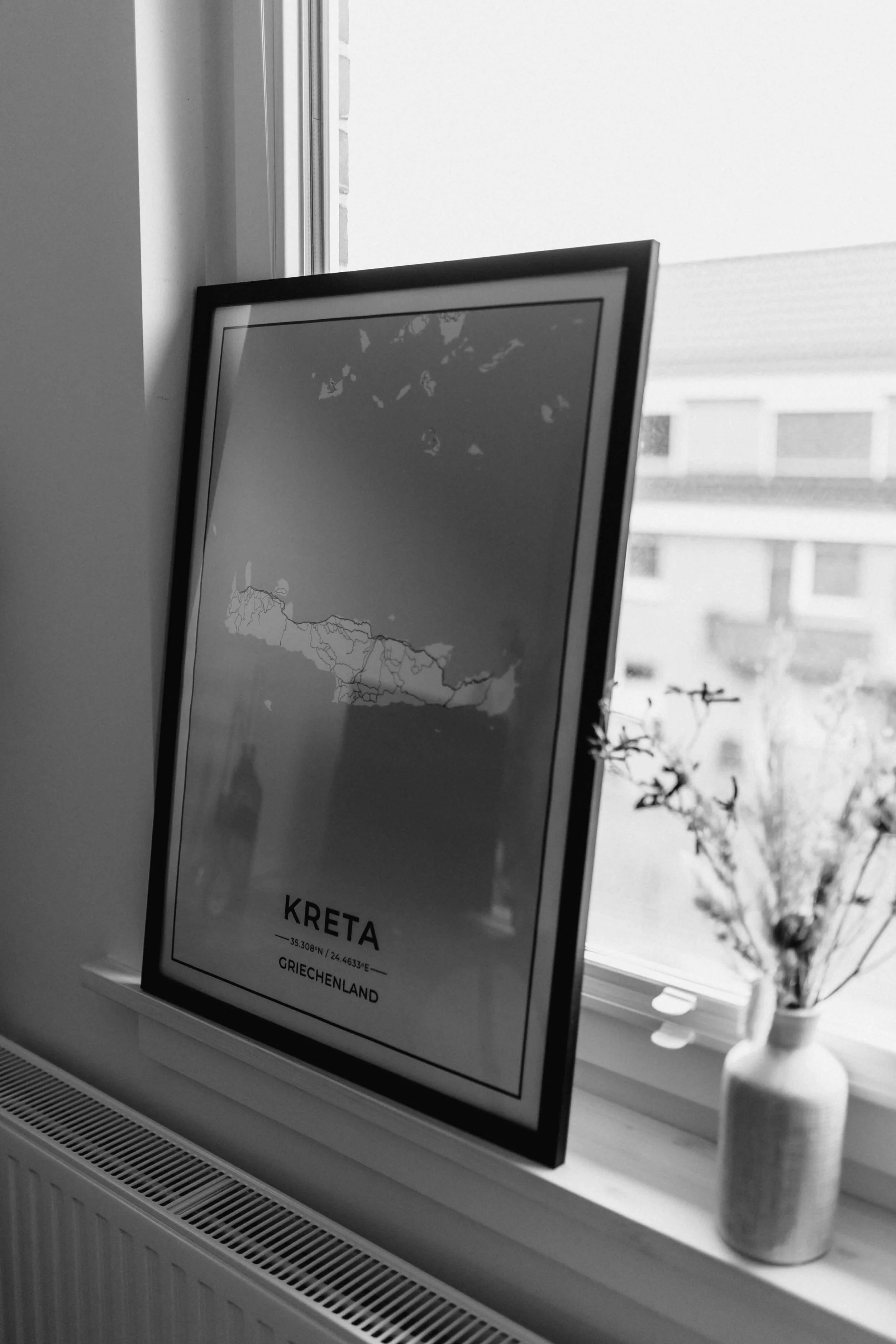 Detailaufnahme in Schwarz-Weiß bei einer Homestory in Lüneburg mit Poster auf der Fensterbank und Vase mit Blumen