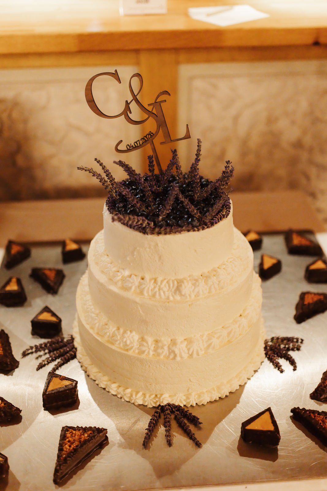 Dreistöckige Hochzeitstorte mit Lavendeldekoration und persönlichem Cake Topper bei einer Hochzeitsfeier im Heide Hotel Reinstorf bei Lüneburg.