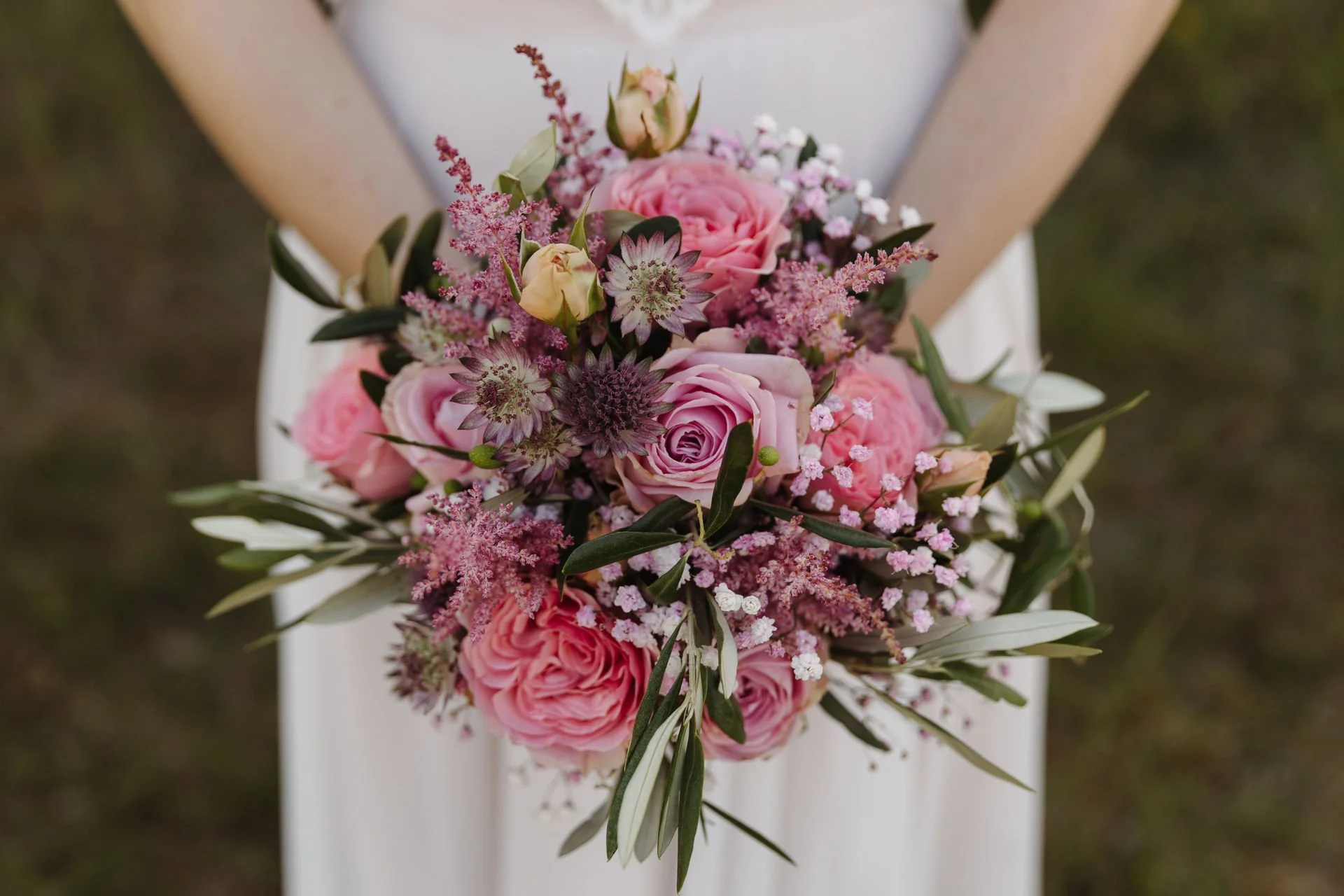 Detailaufnahme eines romantischen Brautstraußes mit rosa Rosen, zarten Blüten und Olivenzweigen bei einer Hochzeit in Lüneburg.