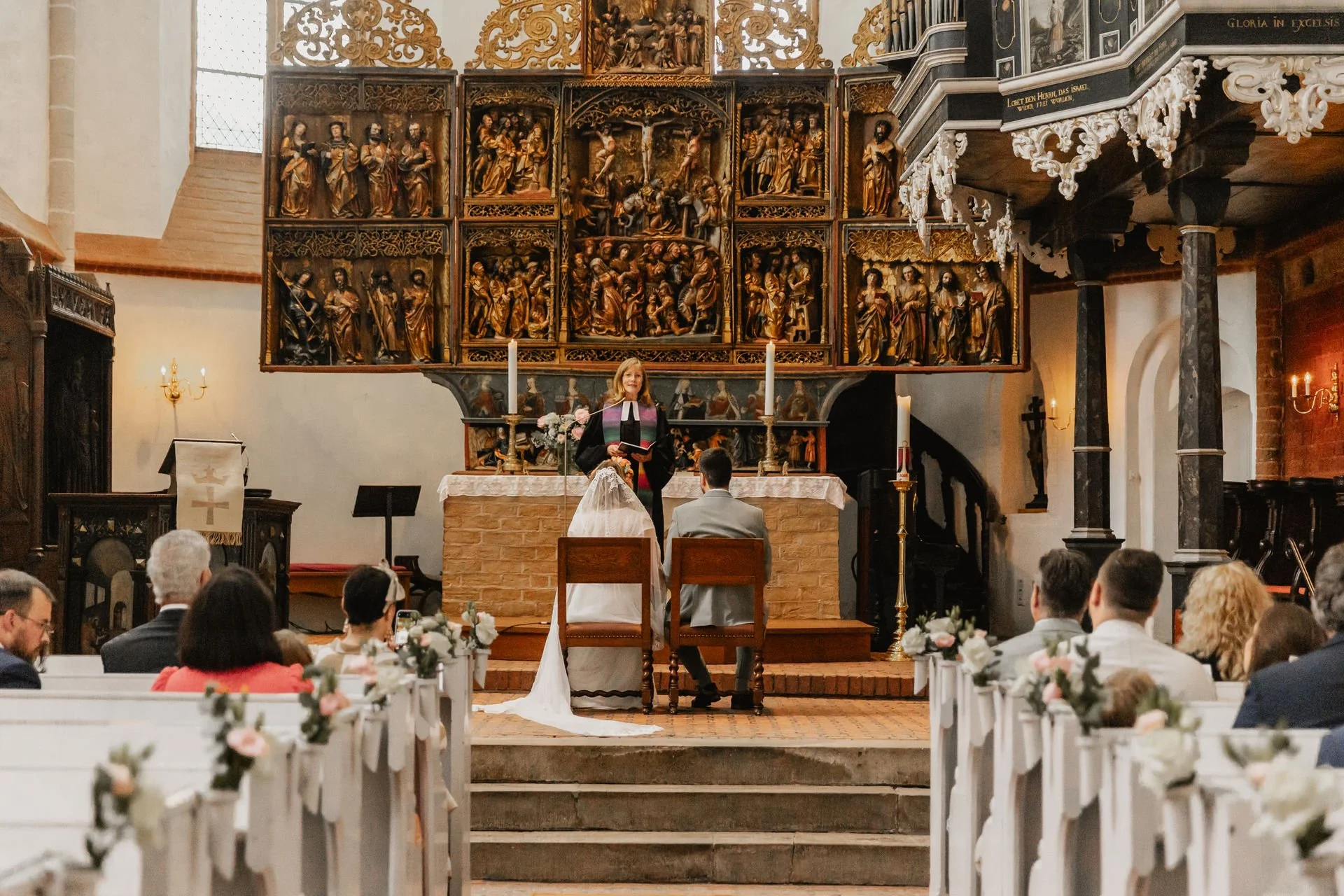 Brautpaar während der Trauung in der festlich geschmückten Kirche in Lüneburg