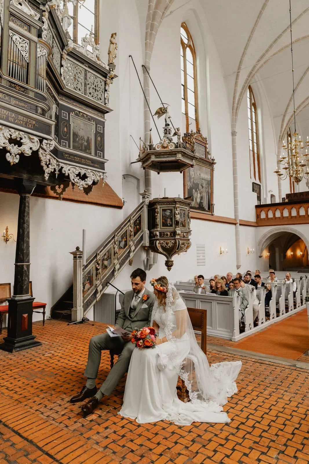 Brautpaar sitzt während der kirchlichen Trauung in einer historischen Kirche in Lüneburg