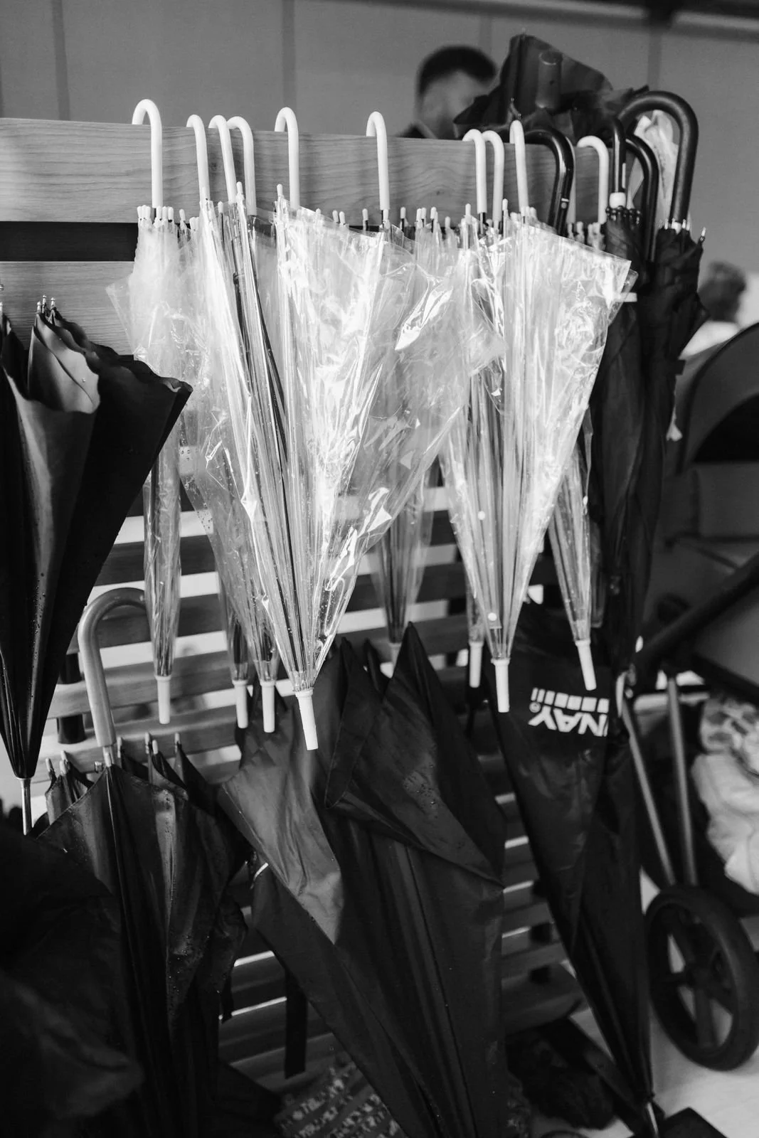 Schwarz-Weiß-Detailaufnahme von transparenten und schwarzen Regenschirmen für die Hochzeitsgäste bei einer Regenhochzeit im Heide Hotel Reinstorf bei Lüneburg.