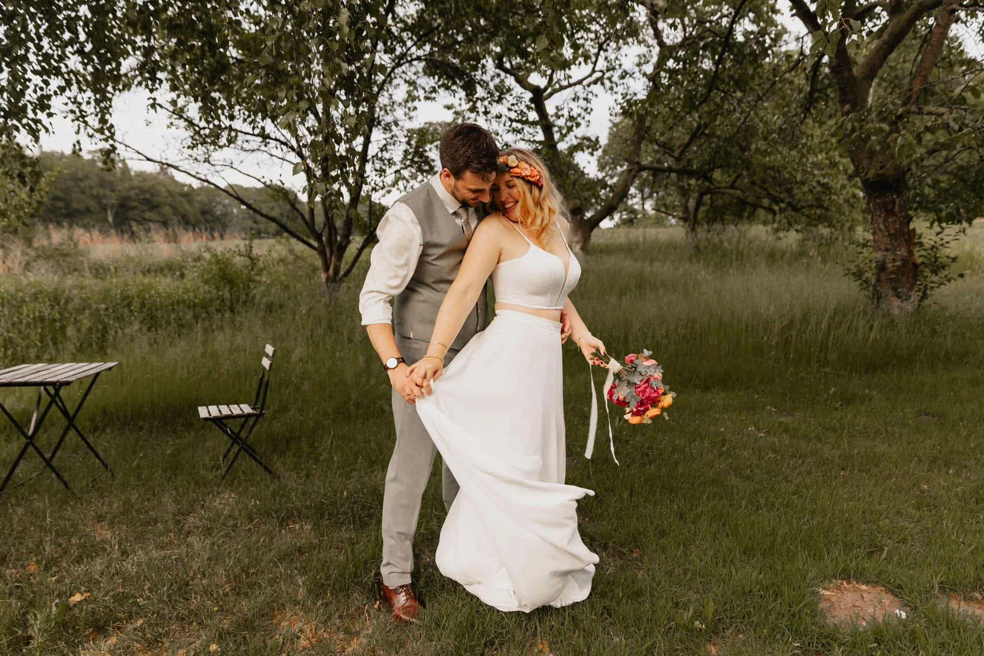 Brautpaar läuft Arm in Arm durch eine grüne Wiese in Lüneburg bei ihrer Hochzeit