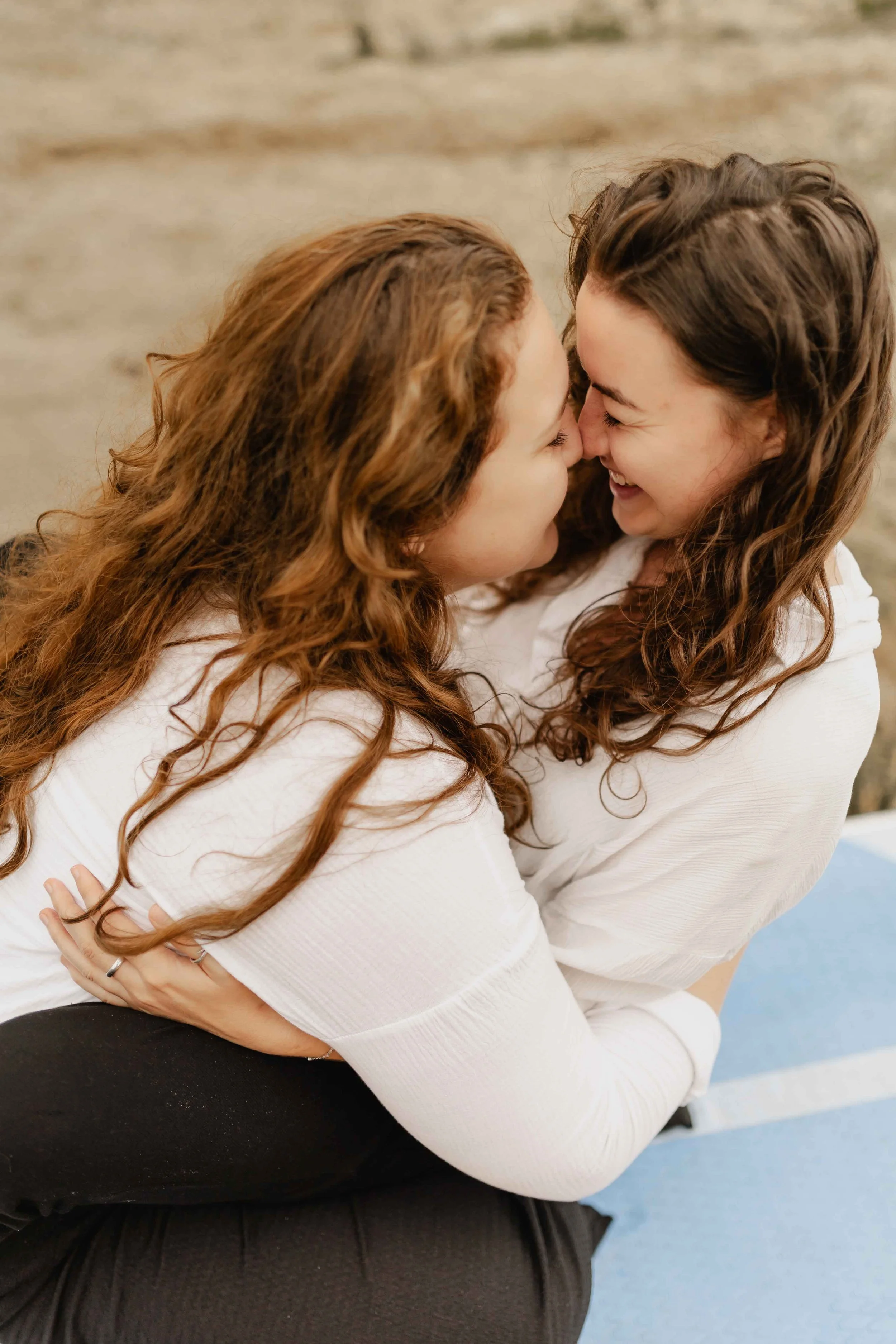Zwei Frauen umarmen sich und küssen sich zärtlich am Oldenstädter See