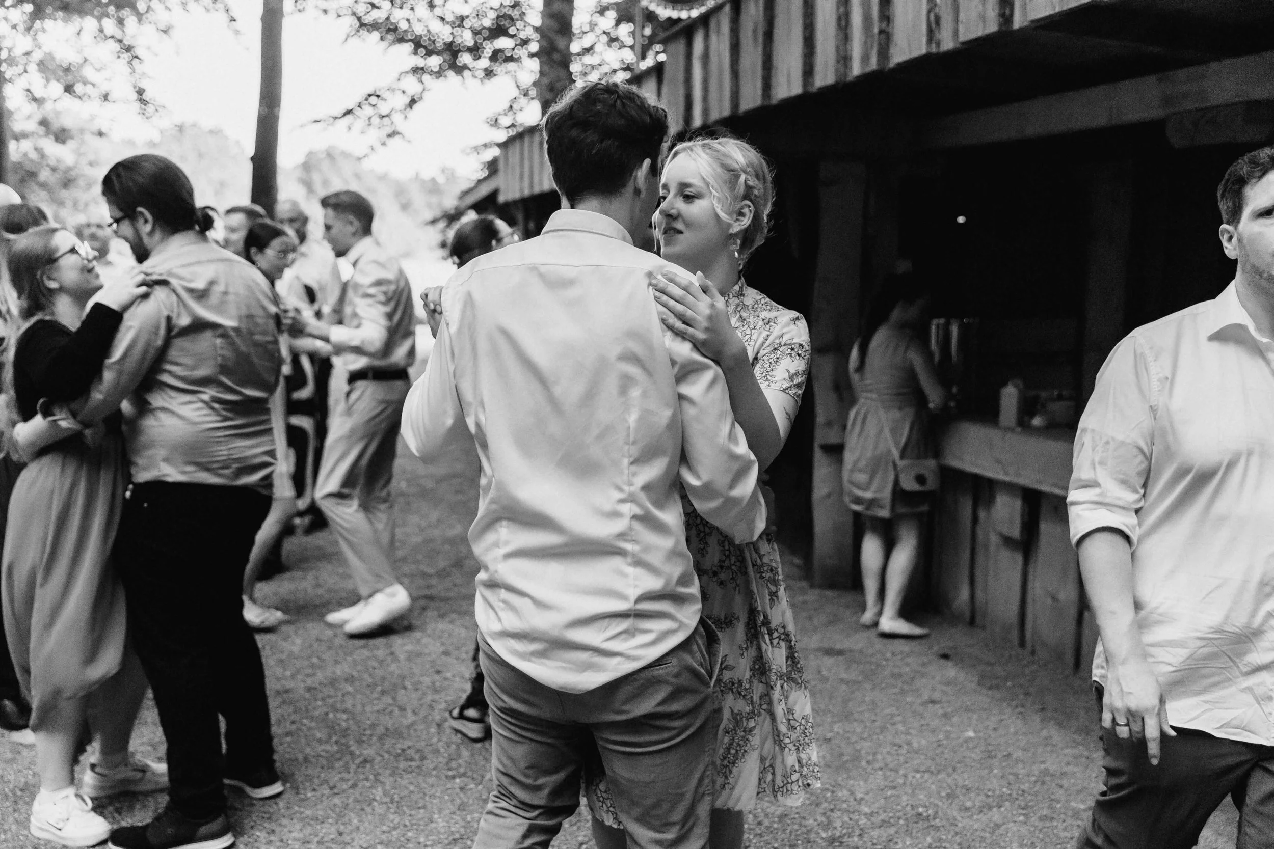 Gäste tanzen eng umschlungen bei der Hochzeit in Schwarzweißaufnahme