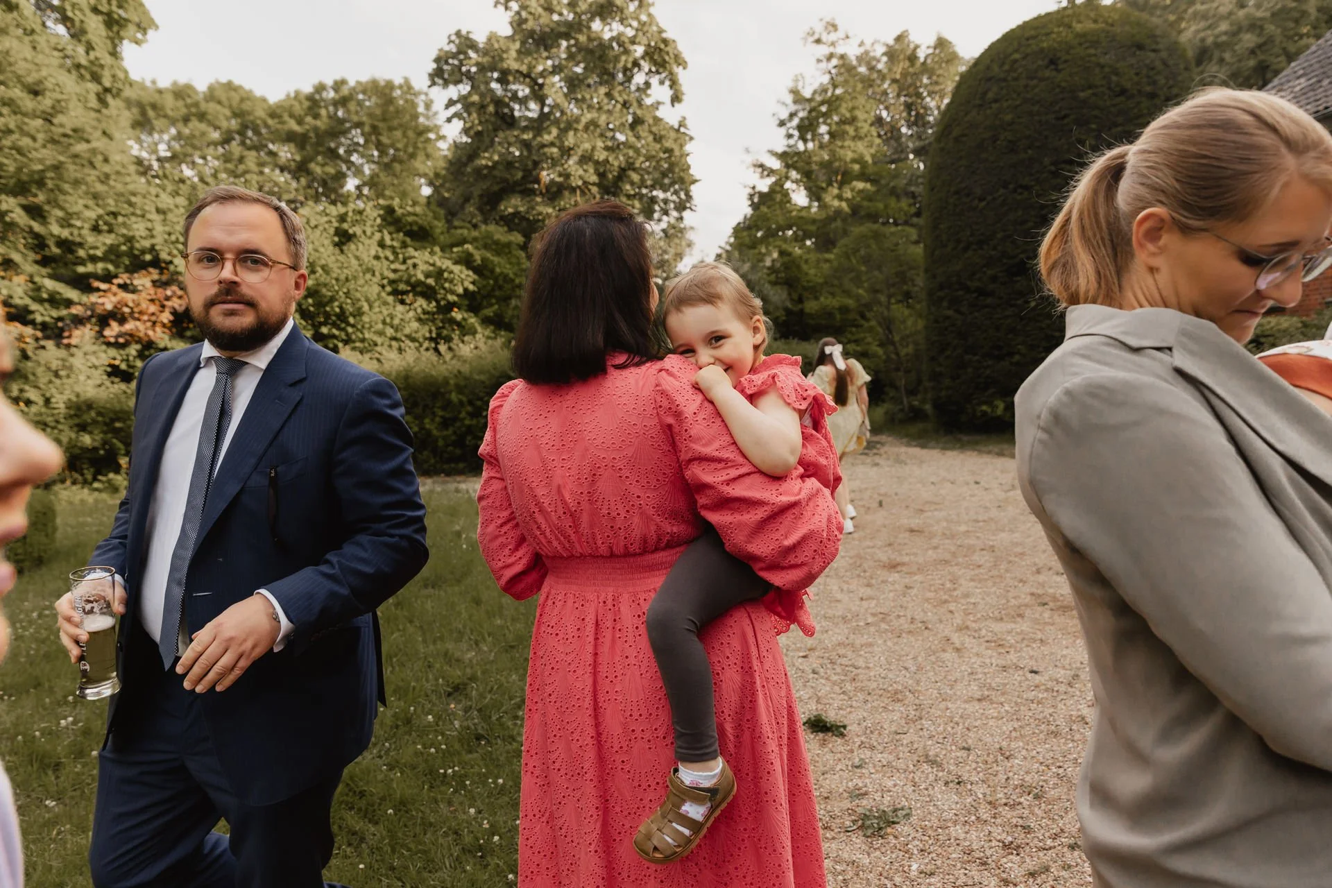 Hochzeitsgäste mit Kindern unterhalten sich im Garten während einer Feier in Lüneburg