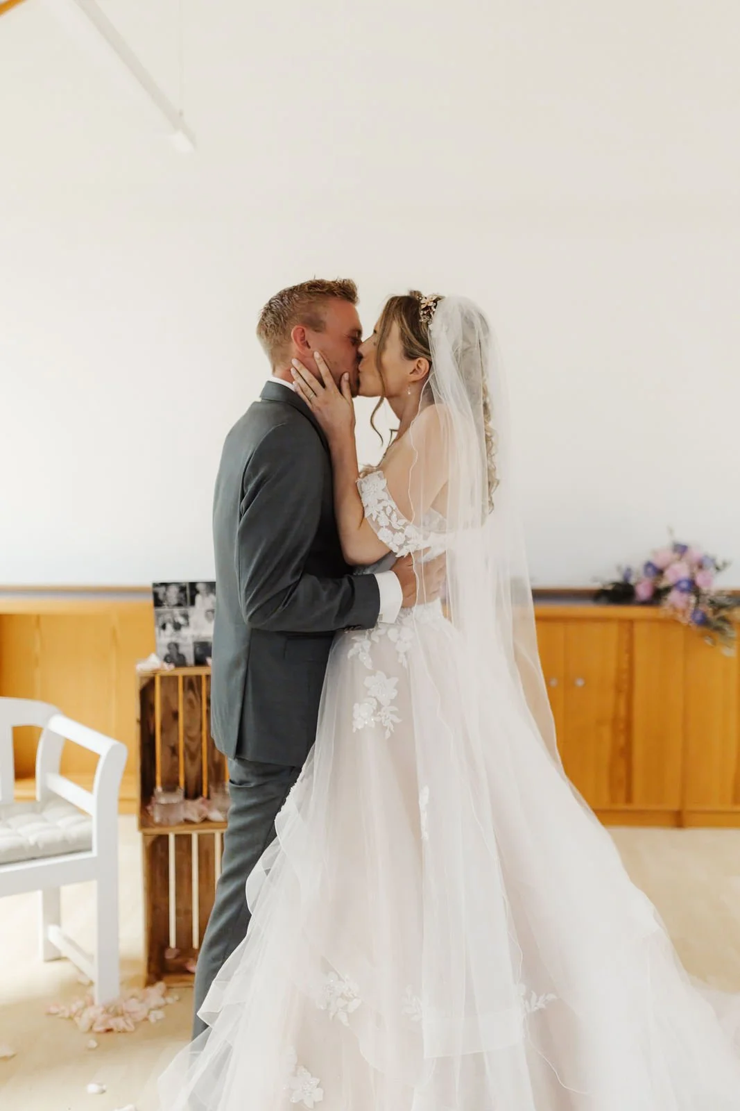 Inniger Hochzeitskuss nach dem Ja-Wort bei der freien Trauung im Heide Hotel Reinstorf bei Lüneburg. Die Braut im romantischen Brautkleid und Schleier küsst ihren Bräutigam.