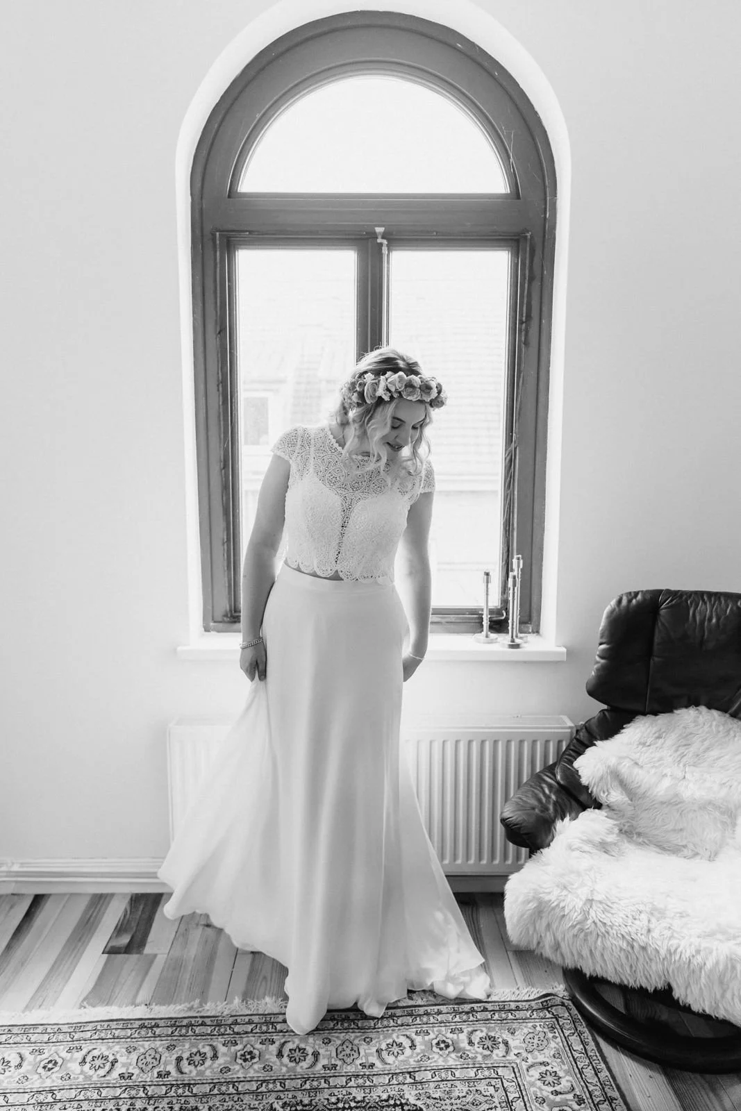 Brautporträt im Hochzeitskleid vor einem großen Fenster beim Getting Ready in Lüneburg in hellem Tageslicht
