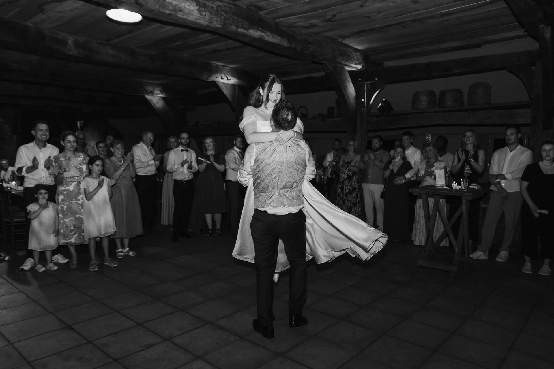 Schwarz-Weiß Aufnahme einer Hebefigur eines Brautpaares beim Hochzeitstanz