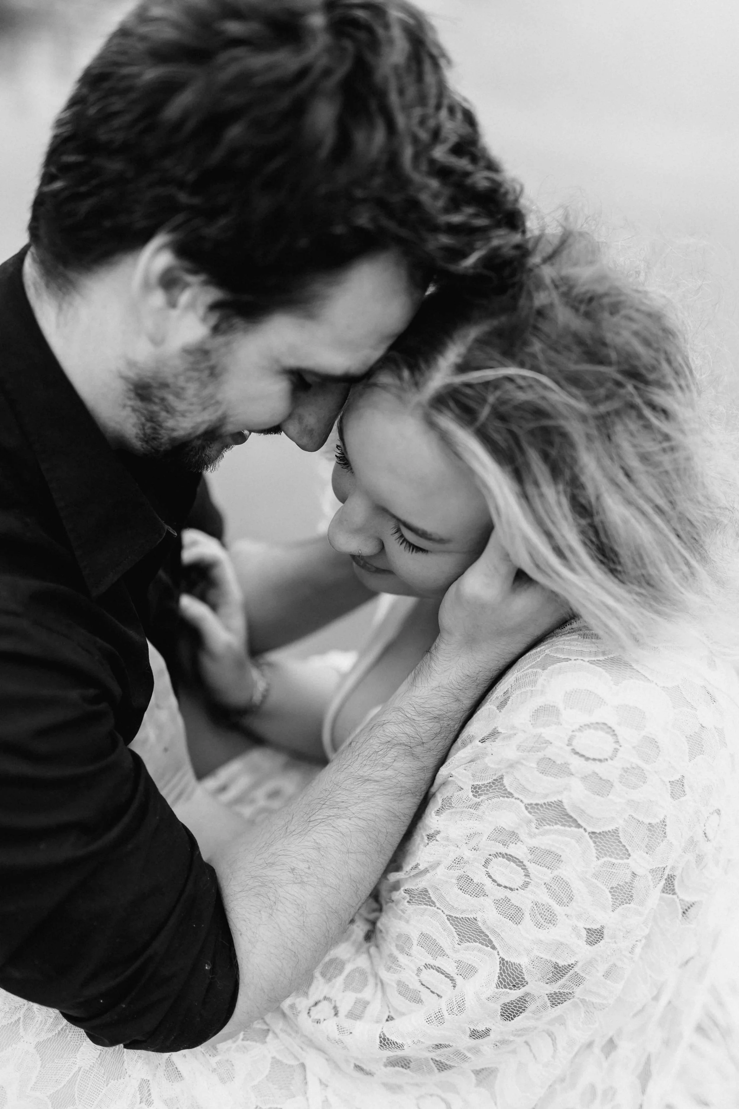 Paar in Schwarz-Weiß-Aufnahme, Stirn an Stirn mit geschlossenen Augen in inniger Umarmung