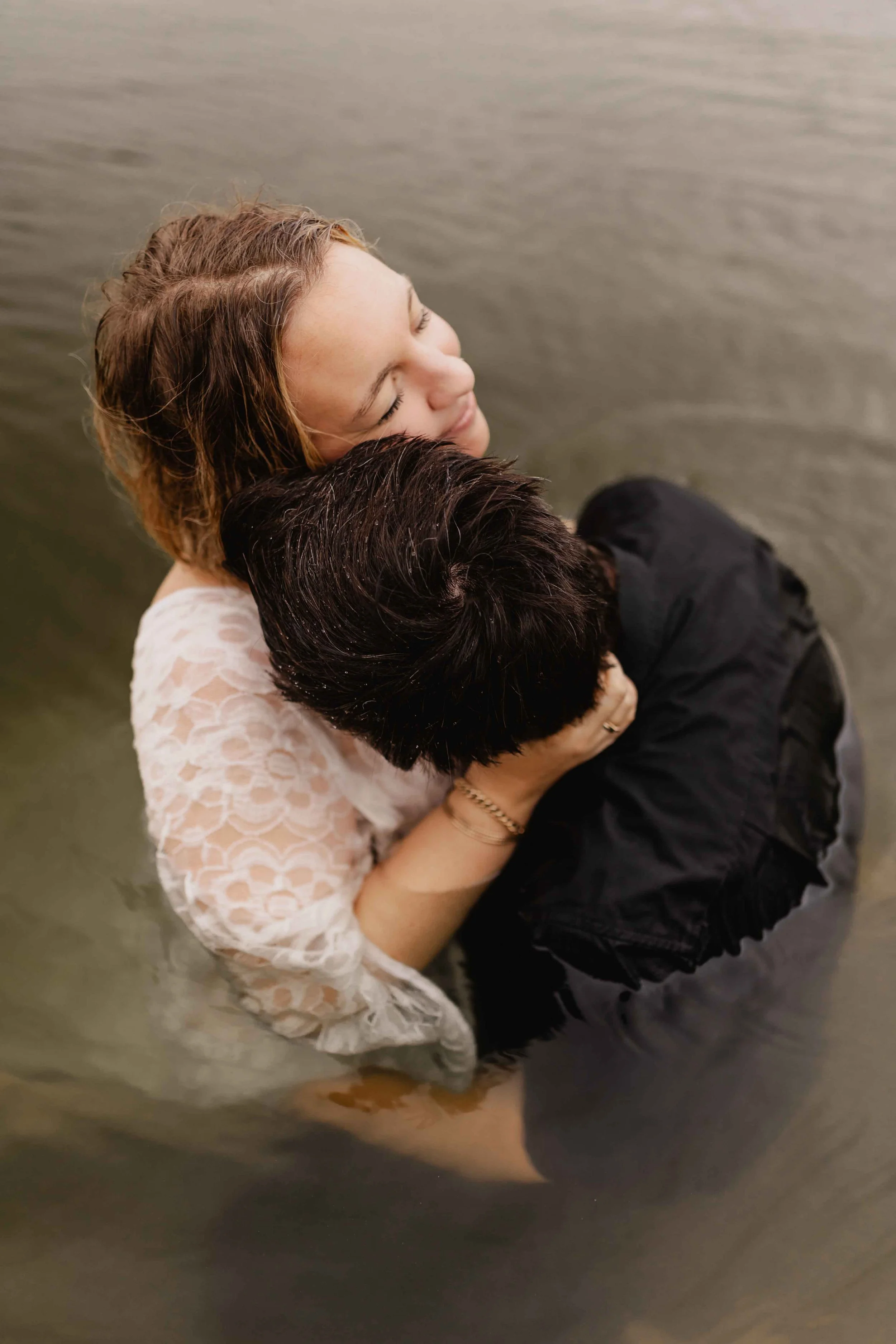 Paar umarmt sich eng im Wasser, fotografiert aus der Vogelperspektive