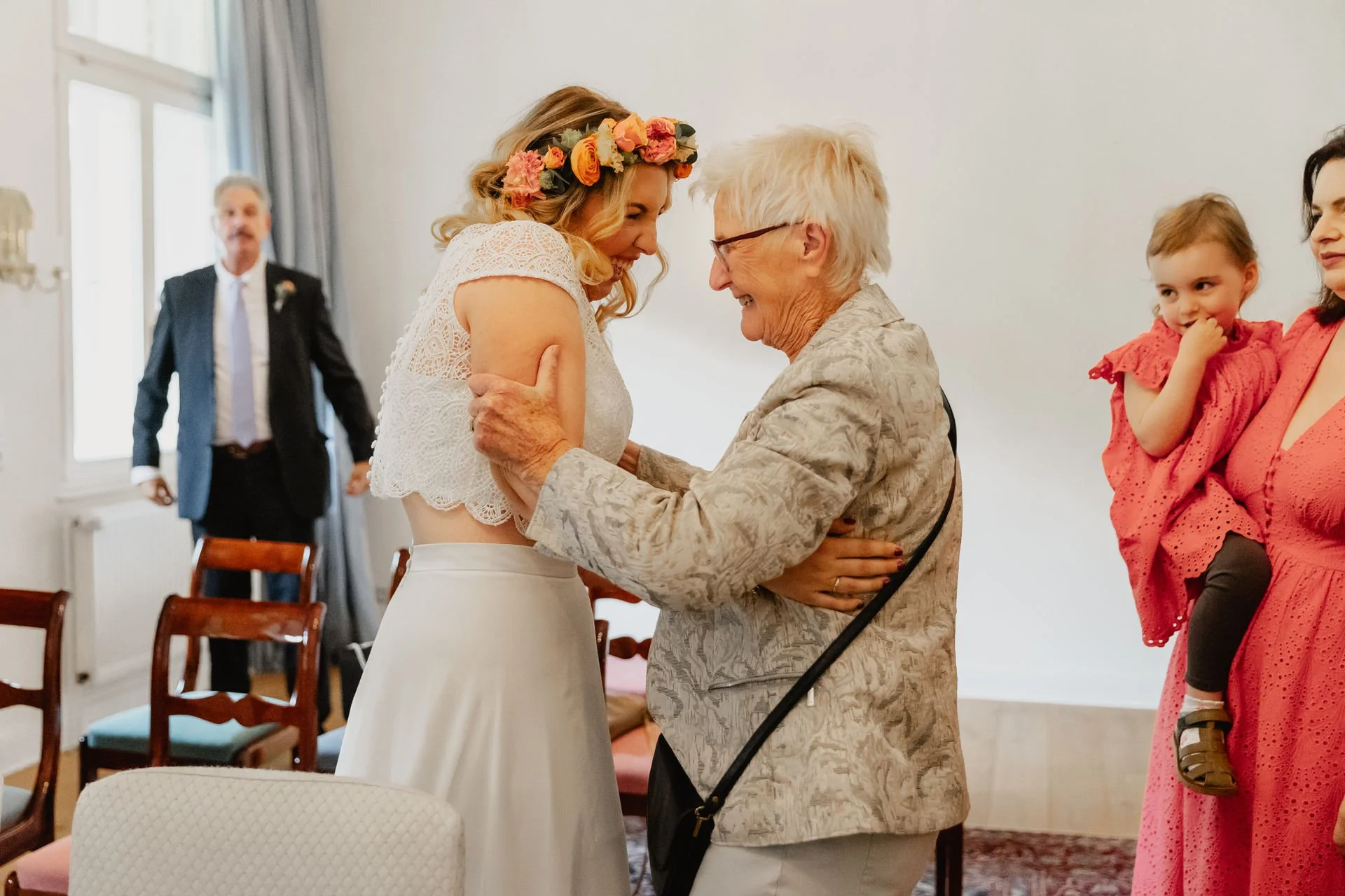 Braut lacht nach der Trauung in Lüneburg mit ihrer Oma und lässt sich beglückwünschen
