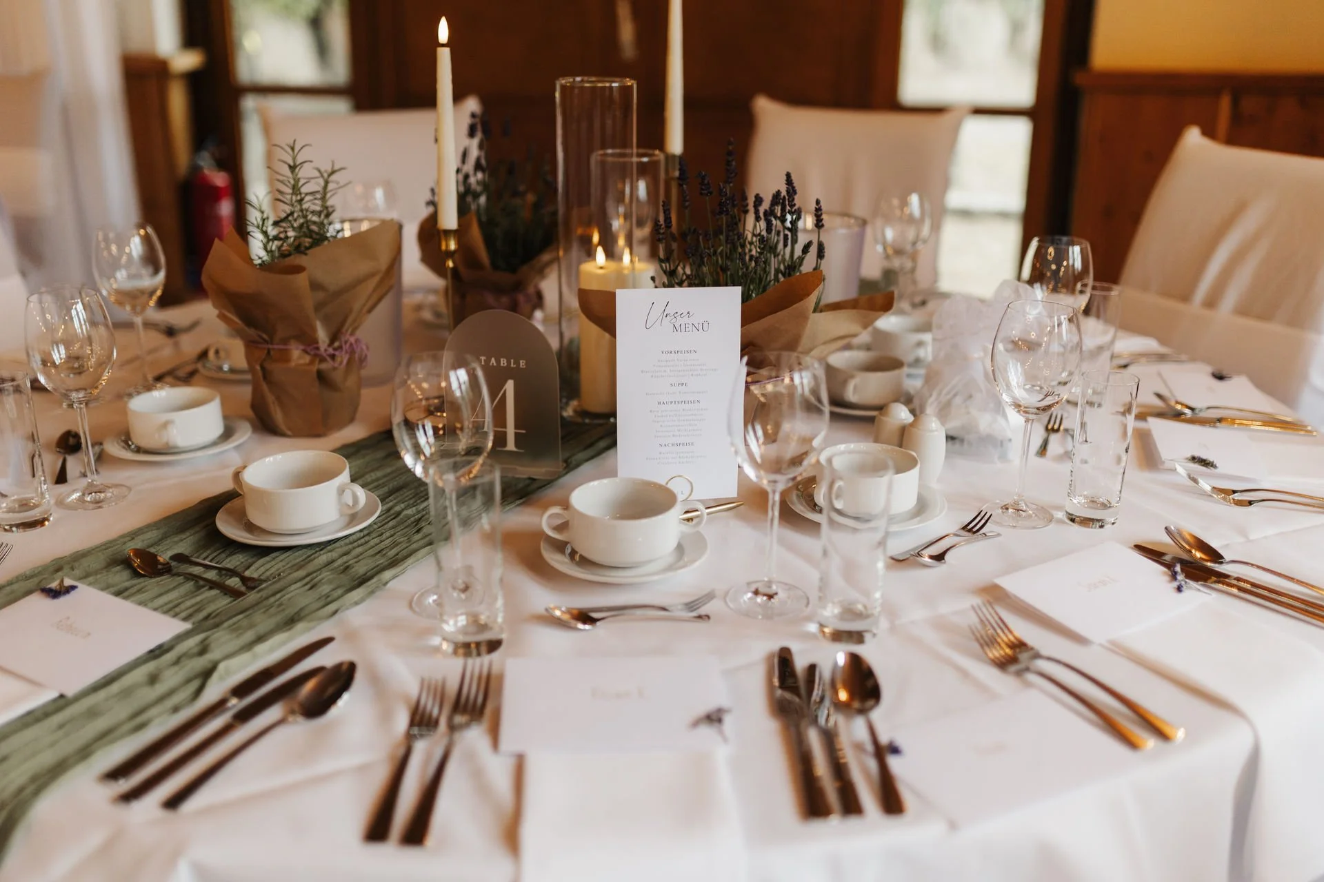 Festlich gedeckter Hochzeitstisch im Heide Hotel Reinstorf bei Lüneburg mit Kerzen, Blumendekoration, Menükarten und eleganter Tischgestaltung.