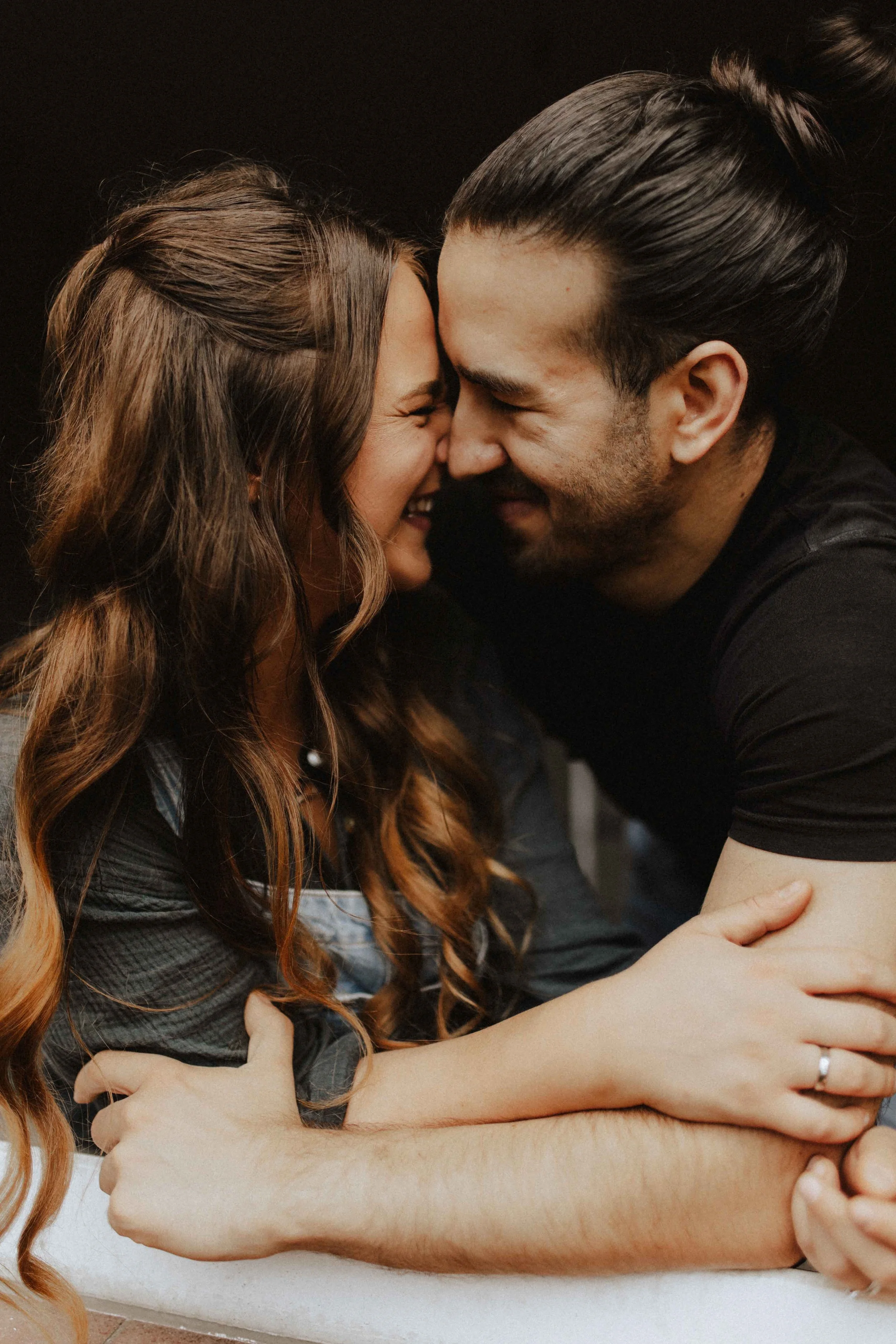 Inniger Moment beim Paarshooting in Lüneburg – verliebtes Paar lacht mit den Stirnen aneinander, warme und natürliche Paarfotografie.