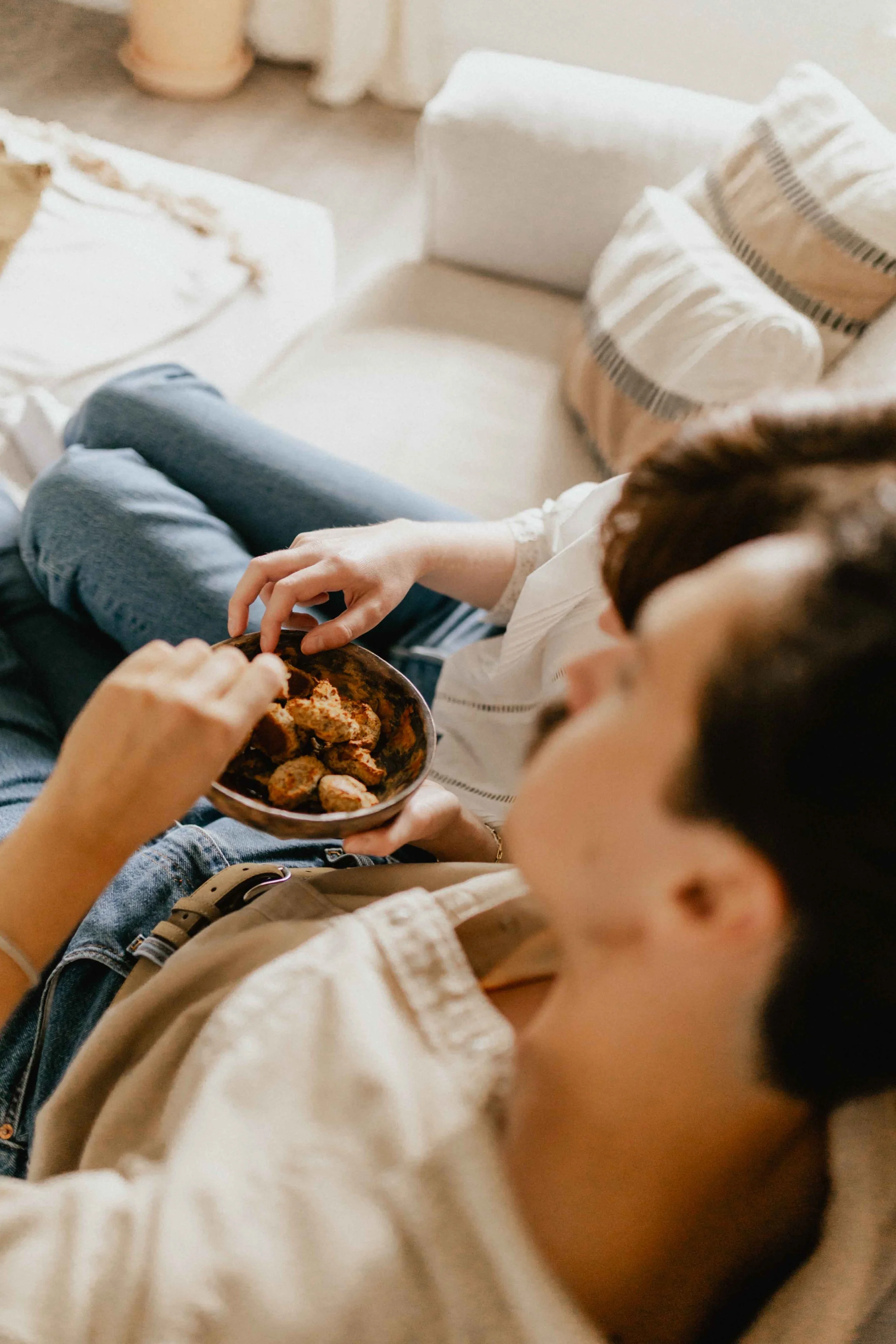Detailaufnahme bei einer Homestory in Lüneburg, Paar sitzt auf dem Sofa und hält eine Schüssel mit frischem Gebäck