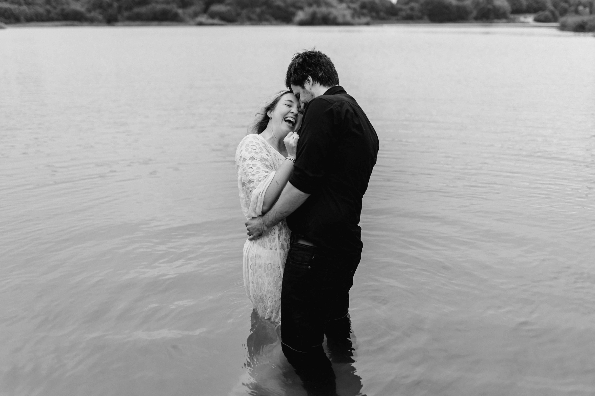 Schwarz-Weiß-Foto eines Paares, das sich eng umarmt und zärtlich im Wasser steht