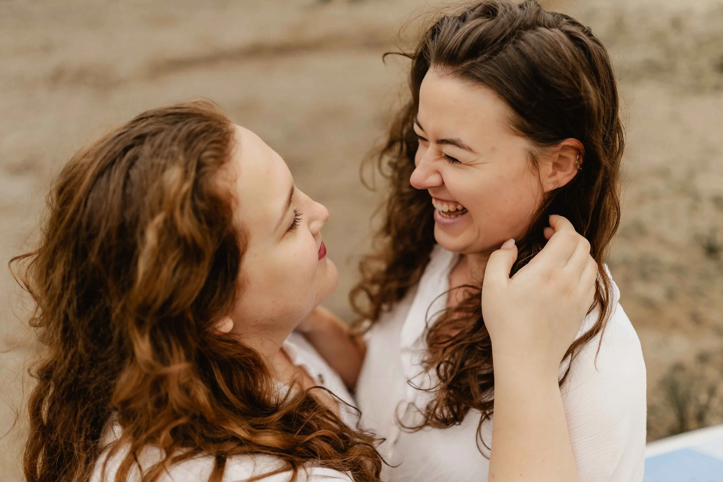 Zwei Frauen umarmen sich und lachen herzlich miteinander am Oldenstädter See