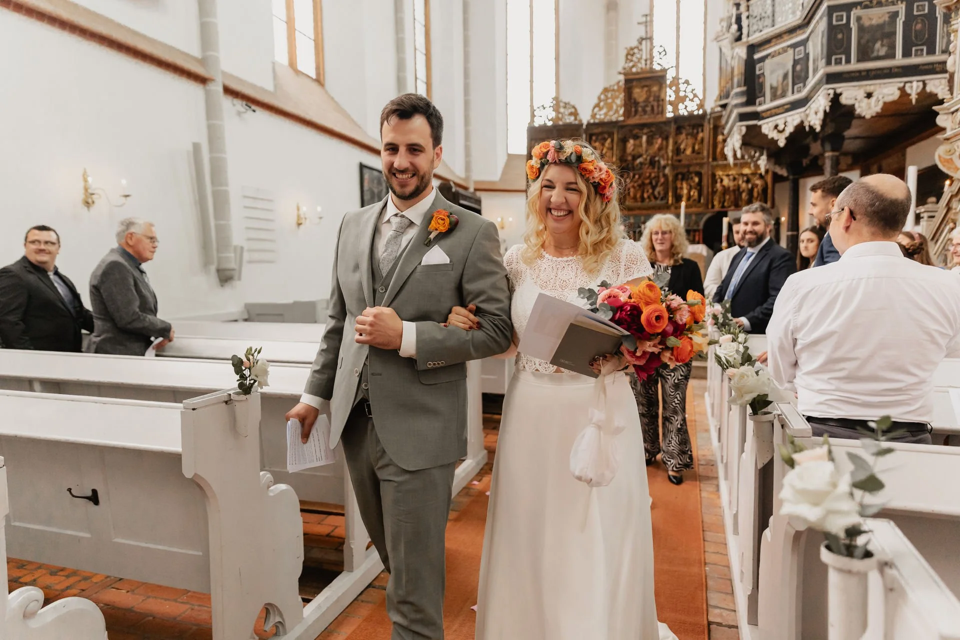 Glückliches Brautpaar verlässt gemeinsam die Kirche nach der Trauung in Lüneburg