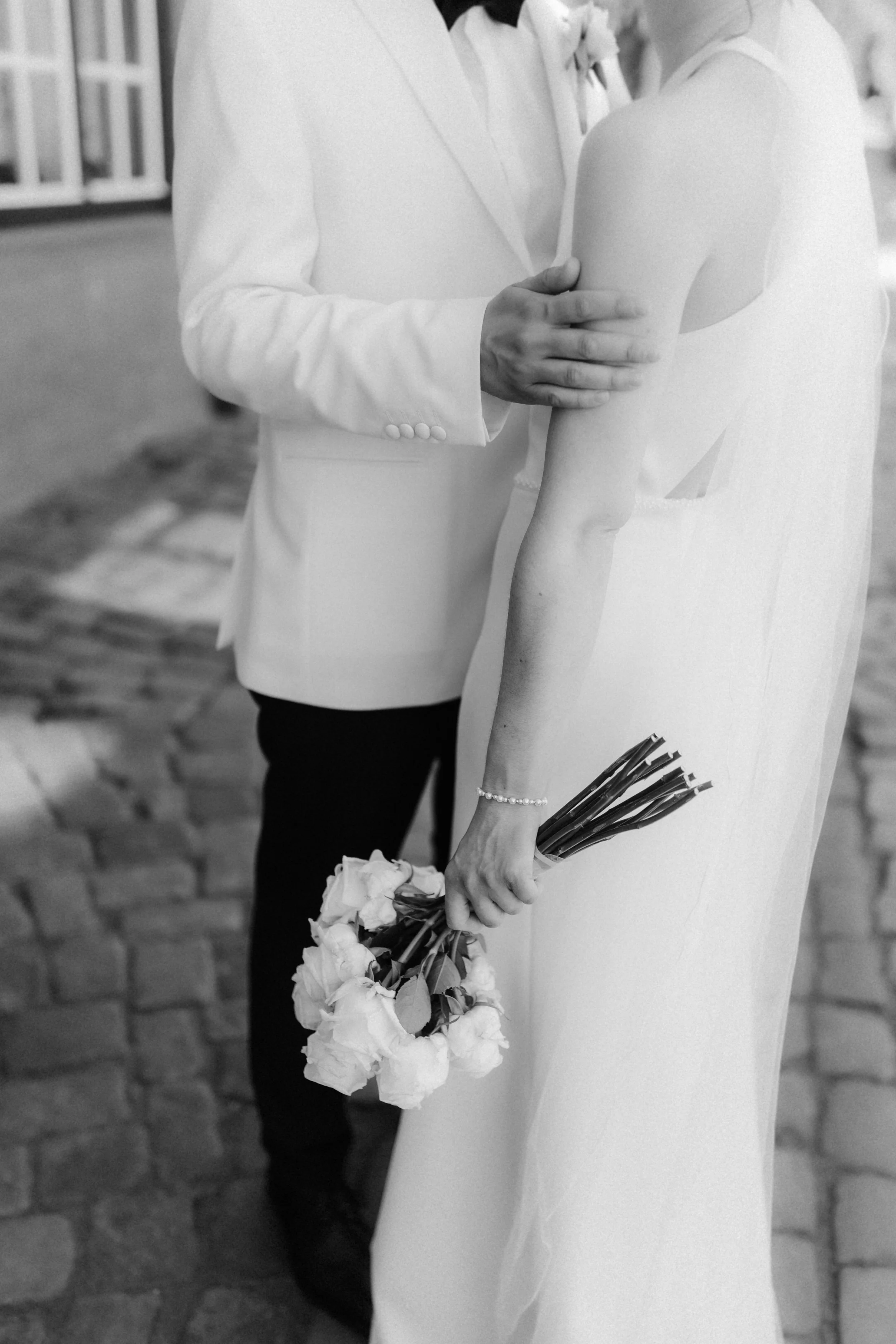 Schwarz-Weiß-Detailaufnahme eines Brautpaares mit Brautstrauß bei einer Hochzeit in Lüneburg.