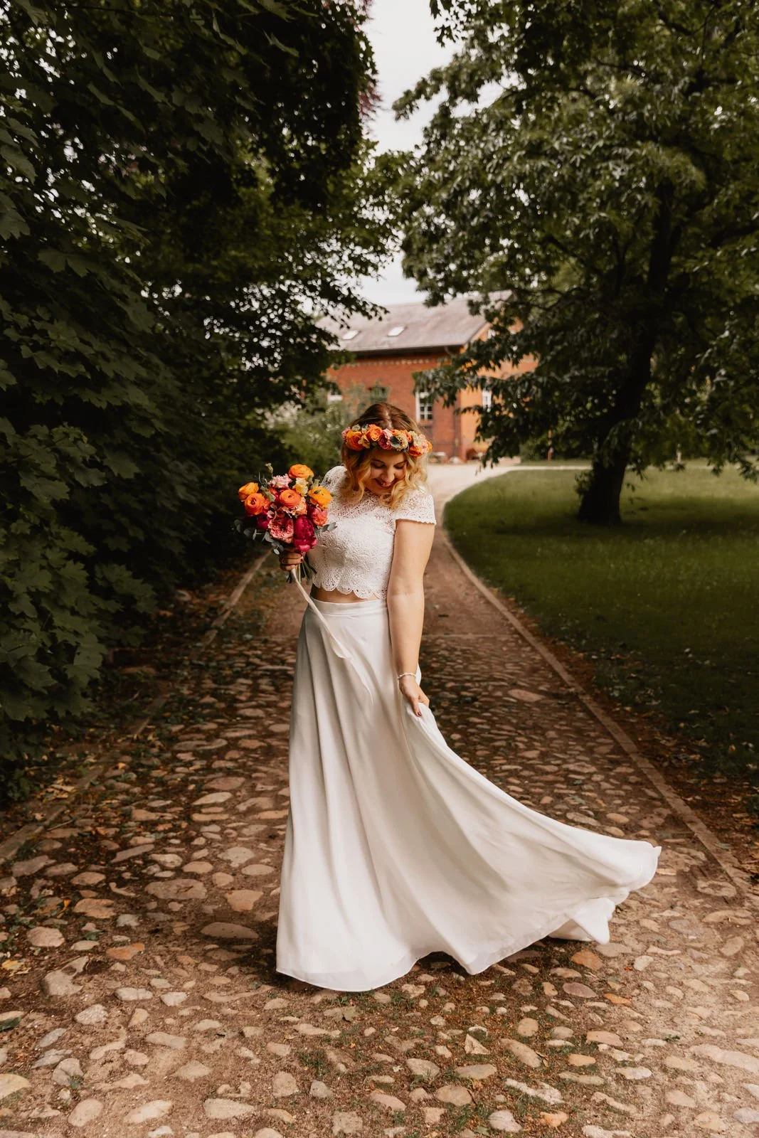 Braut mit Blumenstrauß in der Hand auf einem Weg in Lüneburg aus der Rückenansicht fotografiert