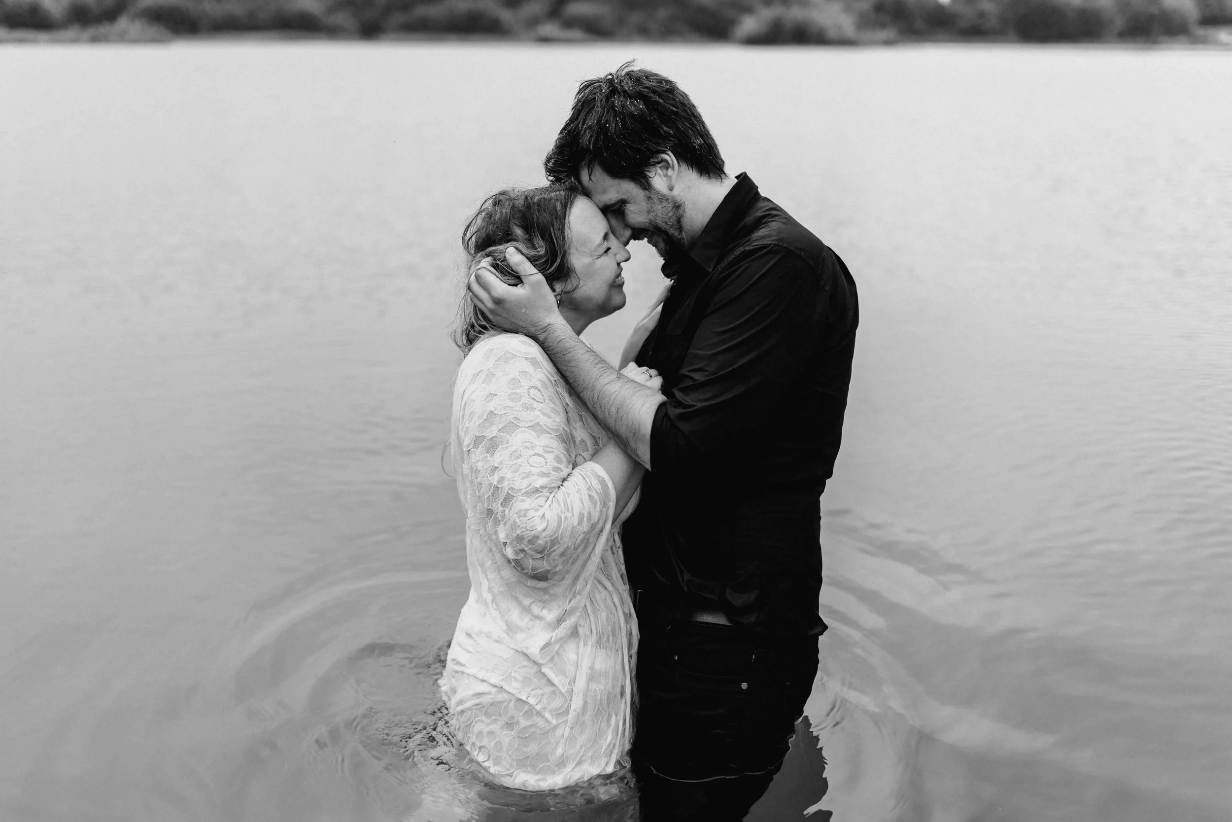 Paar steht eng umschlungen im Wasser mit Stirn an Stirn