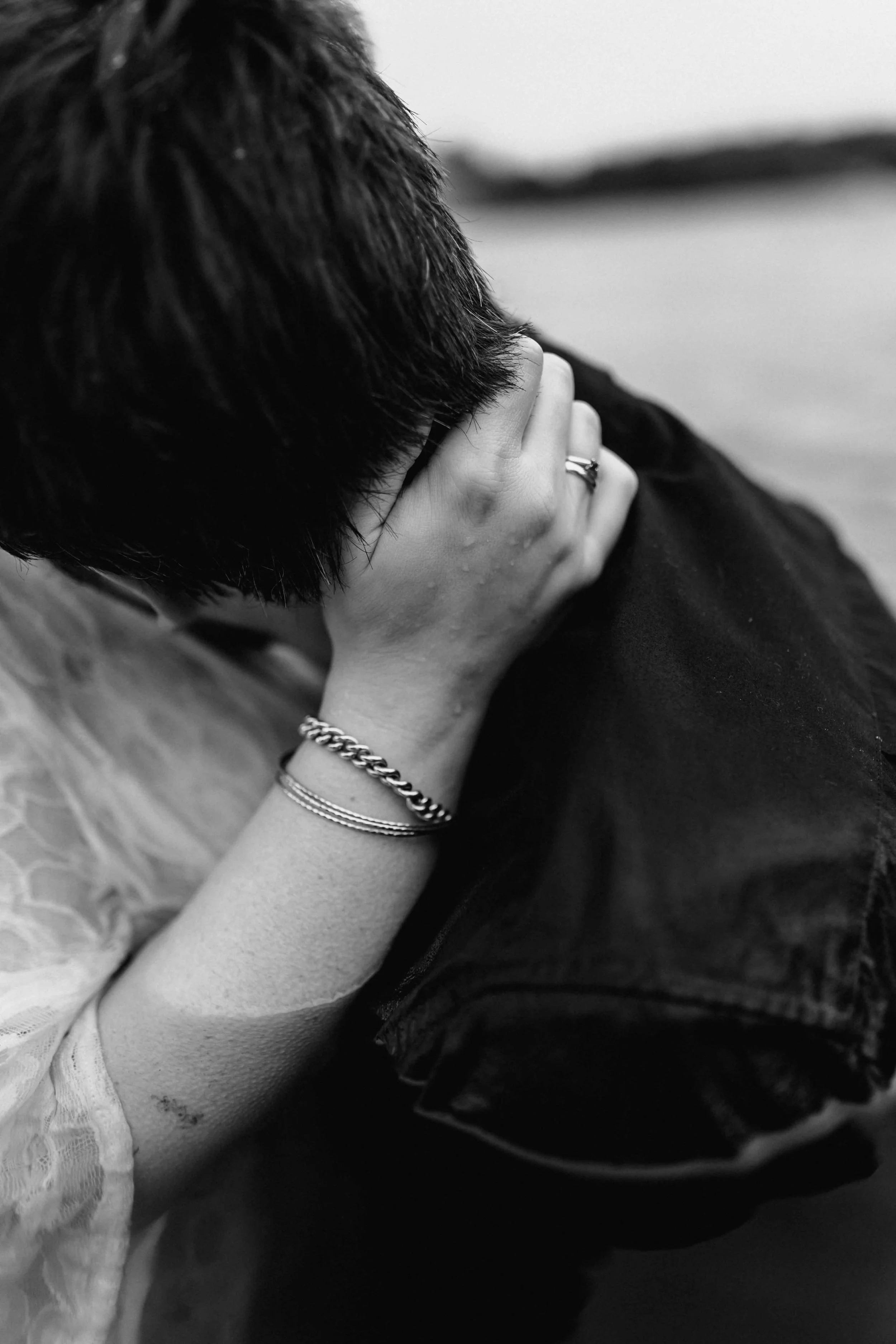 Frau umarmt ihren Partner im Wasser und hält ihn am Nacken fest