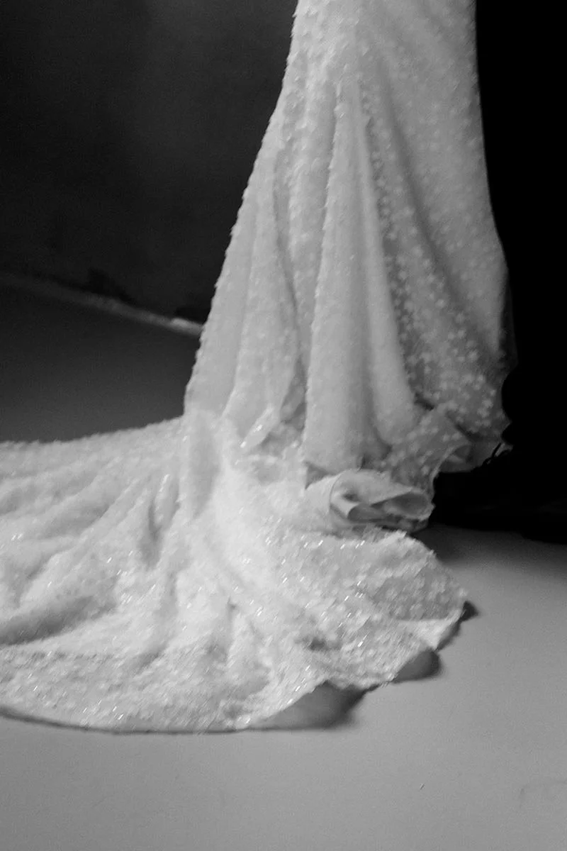 Schwarz-Weiß-Detailaufnahme eines langen Brautschleiers mit feiner Spitze, der weich über den Boden fällt
