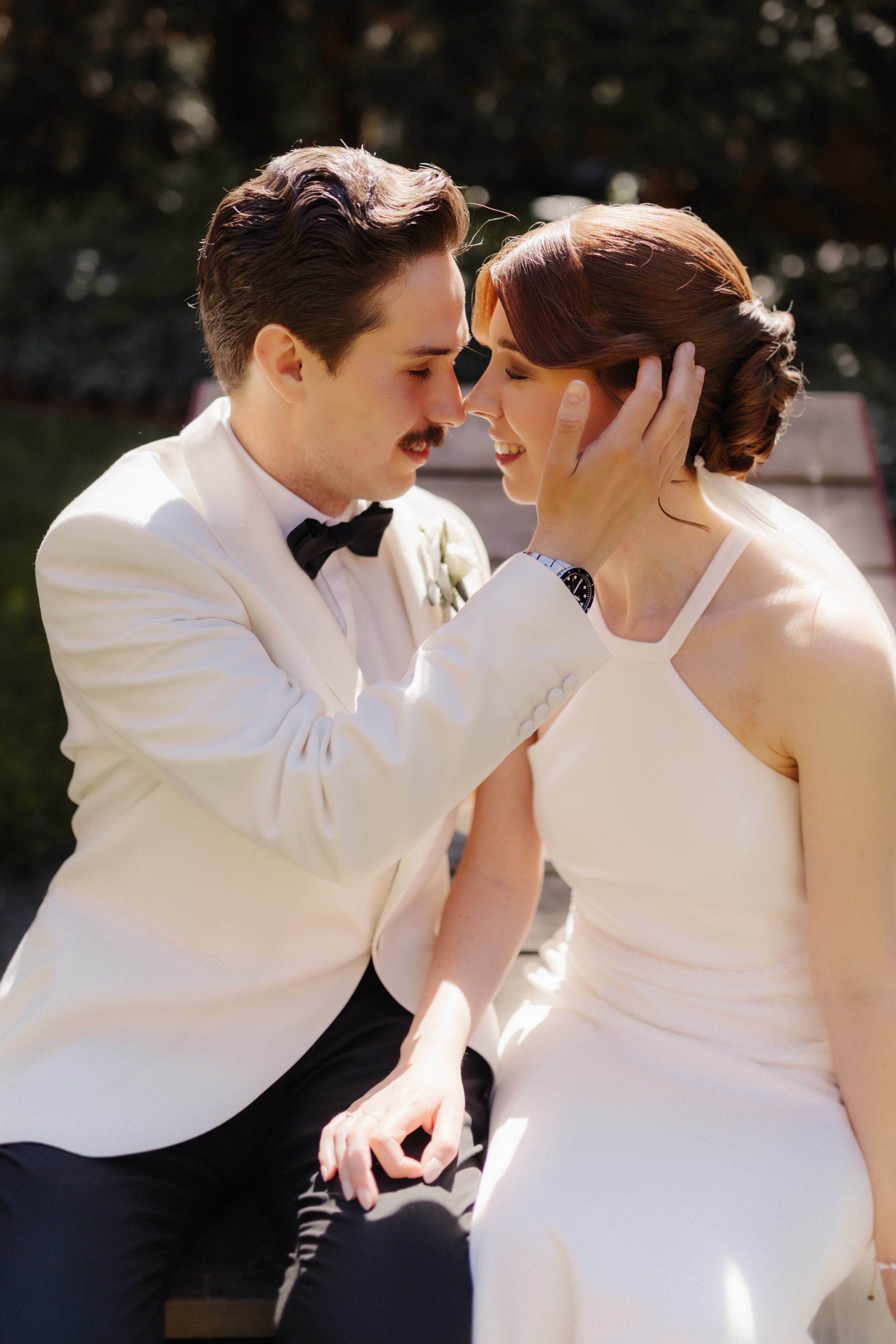 Inniger Moment eines Brautpaares bei ihrer Hochzeit in Lüneburg, während der Bräutigam seiner Braut sanft über die Wange streicht.