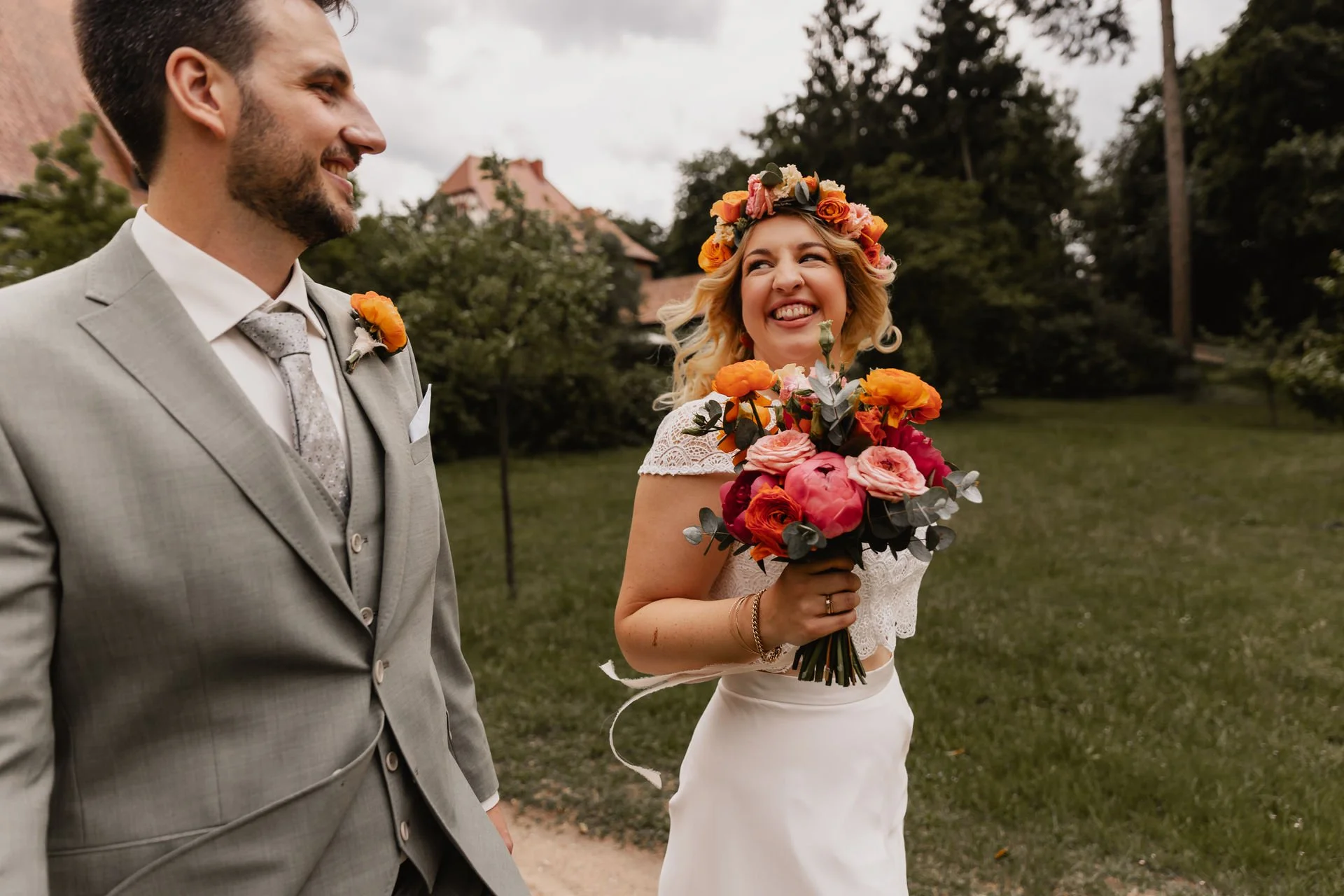Lachendes Brautpaar mit Blumenkranz und Brautstrauß im Freien in Lüneburg