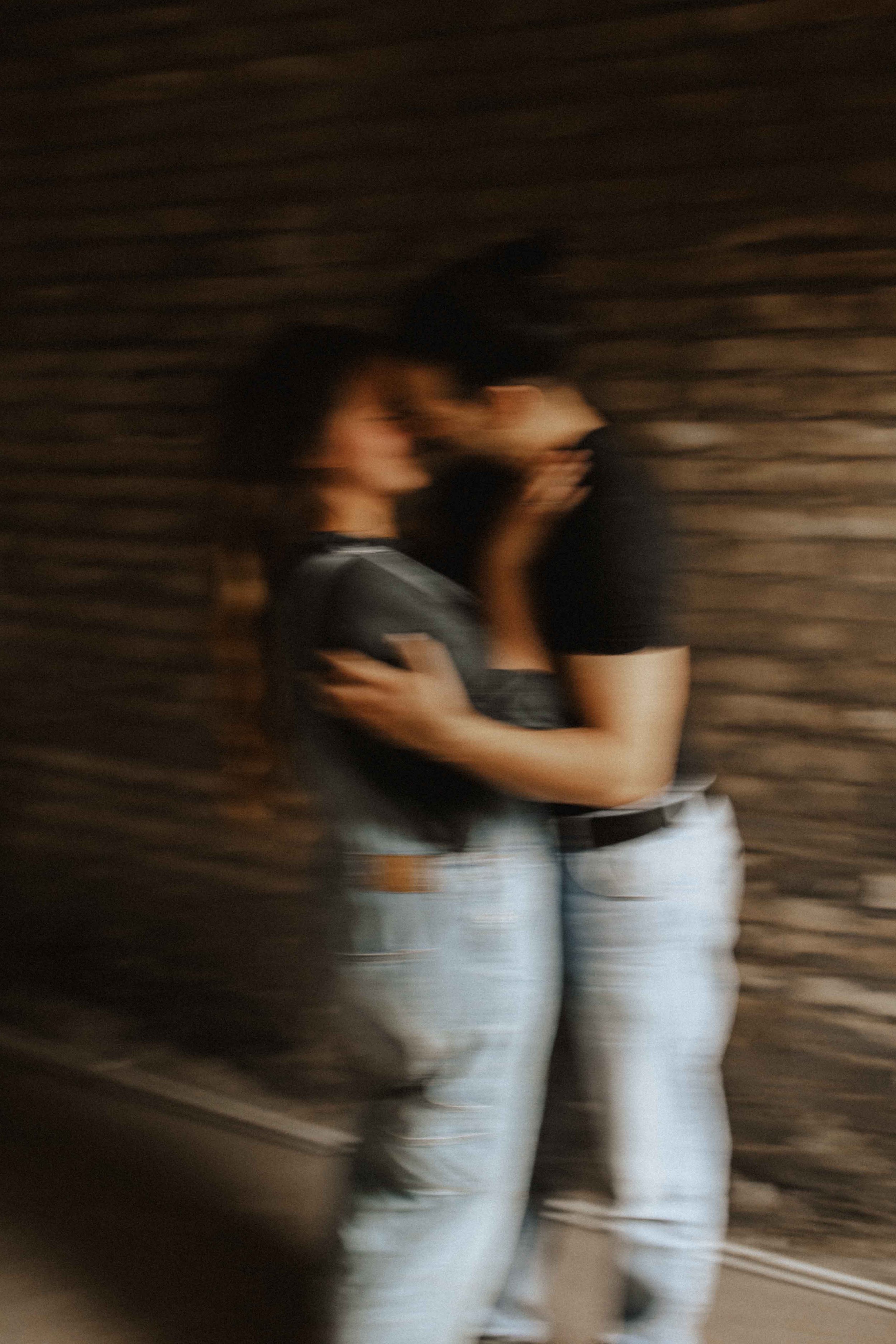 Kreativ unscharfe Aufnahme eines Paares beim Paarshooting in Lüneburg – innige Umarmung und romantischer Moment vor rustikaler Backsteinwand.