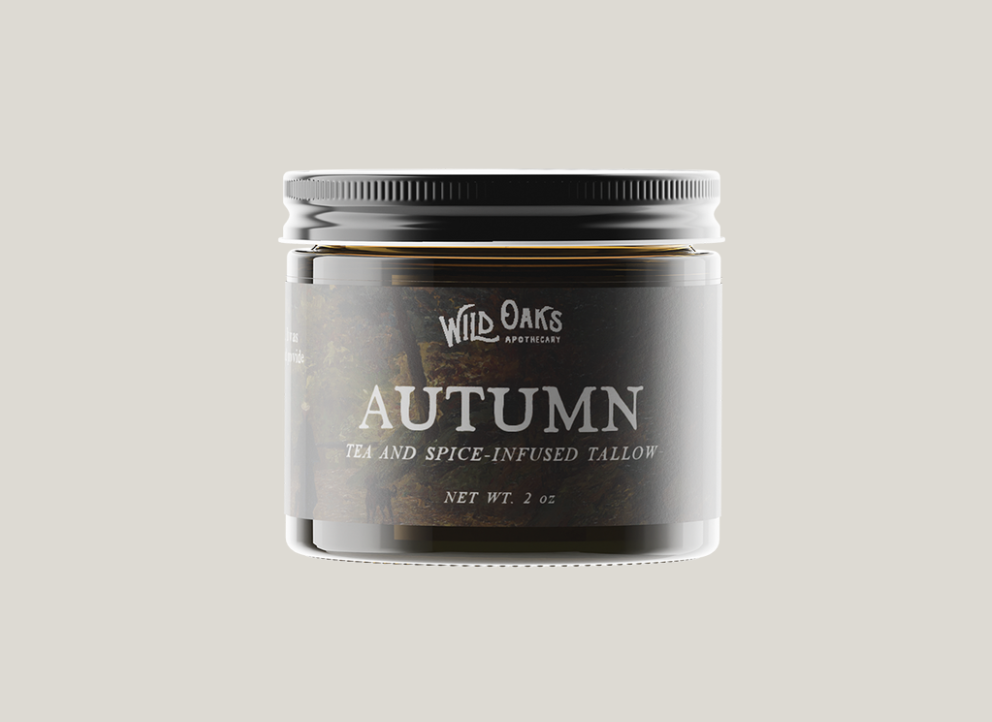 A jar of tea and spice-infused tallow labeled "Autumn" by Wild Oaks Apothecary on a light background.