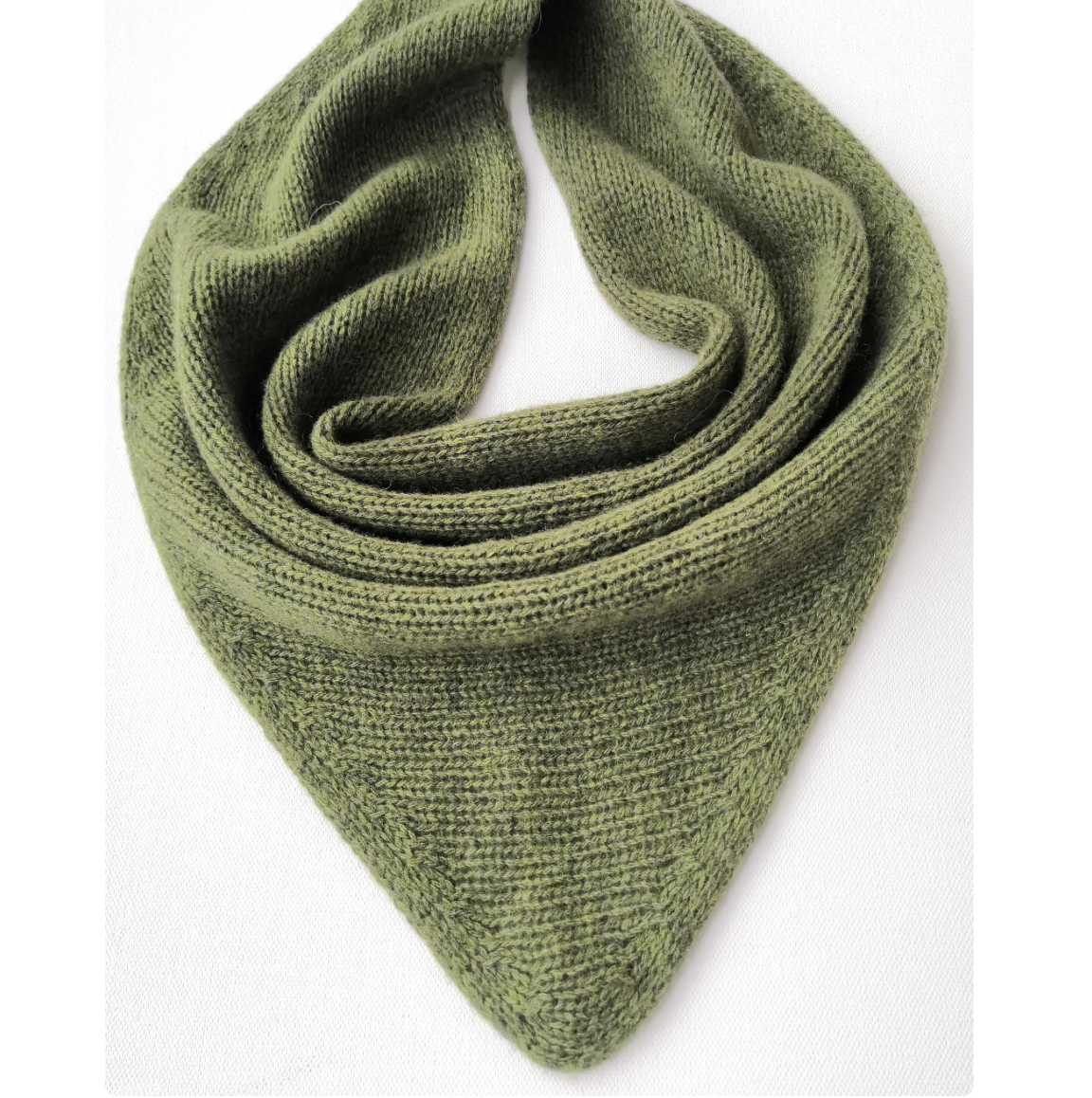 Green knitted scarf with triangular shape, folded on a white background.