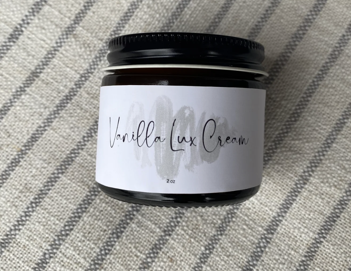 Vanilla Lux Cream jar on a striped fabric background