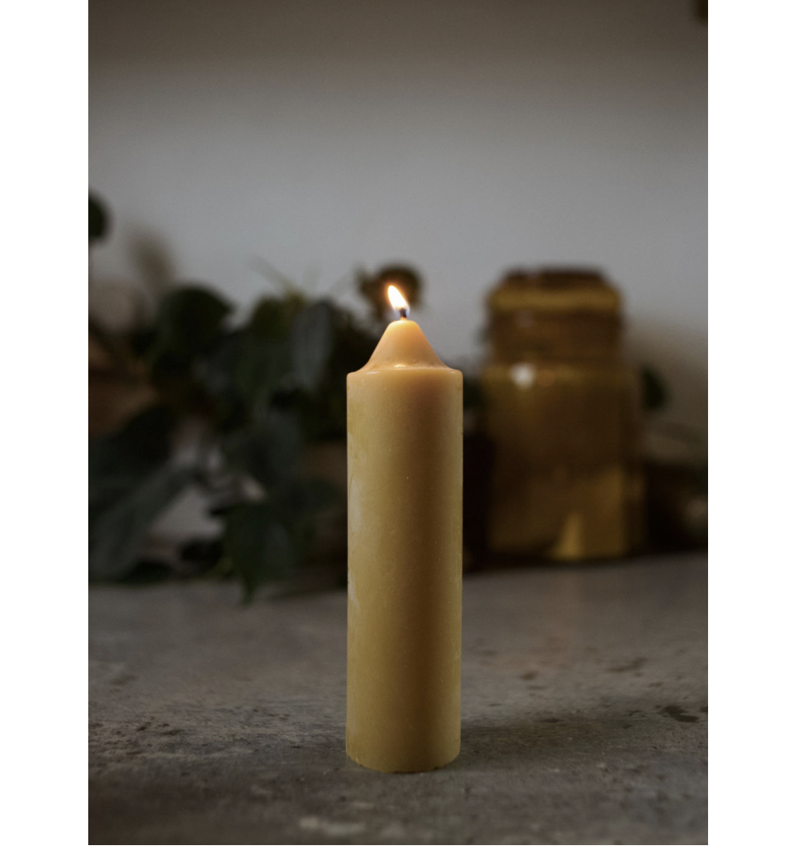 Lit candle on a surface with blurred background