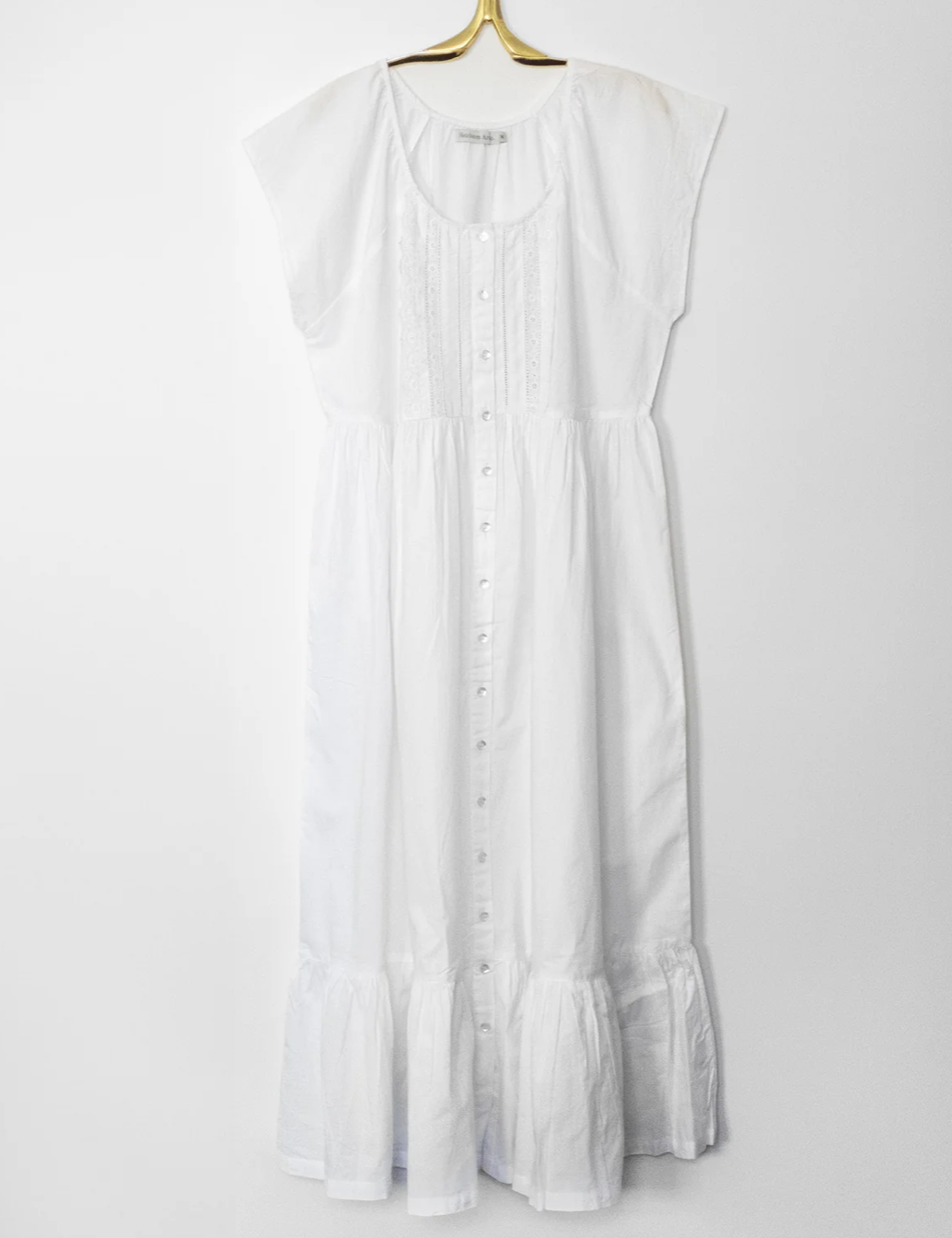 White button-up dress with lace and pleats on hanger