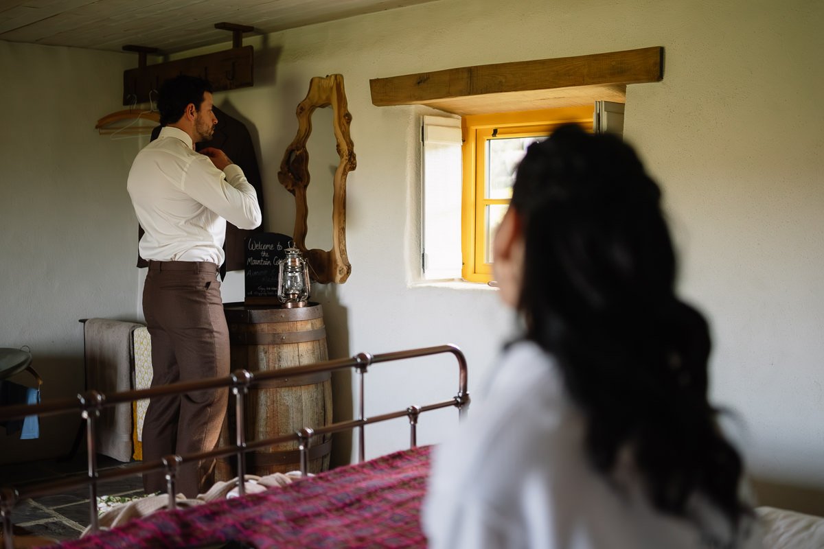 Groom getting ready in a cosy Irish cottage before an elopement