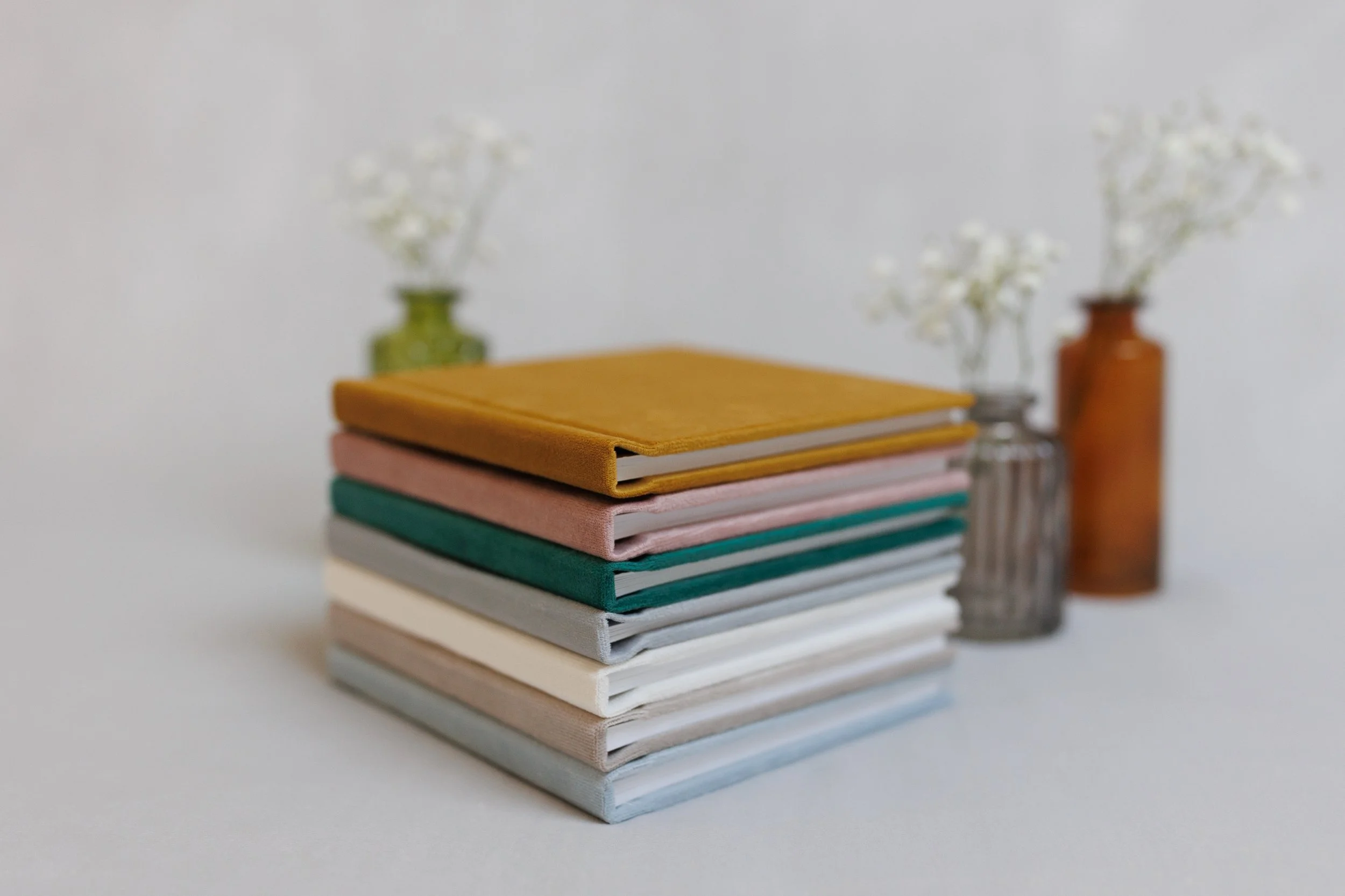 A vibrant and artistic display of books with colorful flowers placed inside the tub