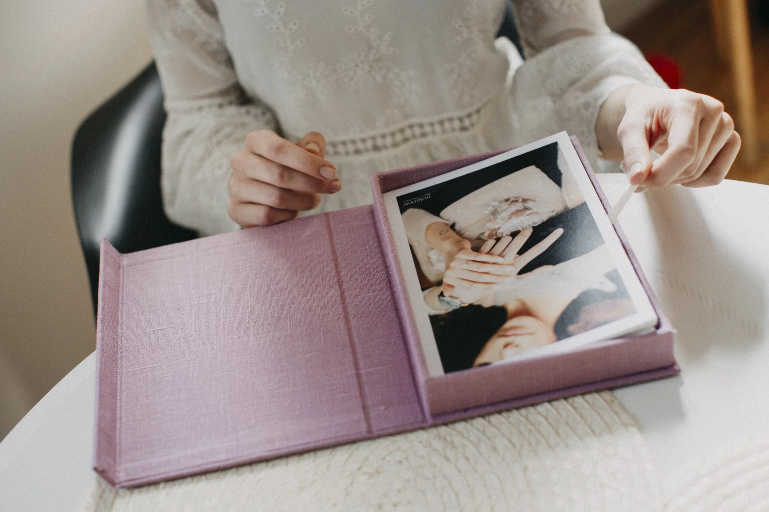 A sitting woman with white dress is looking at wedding album