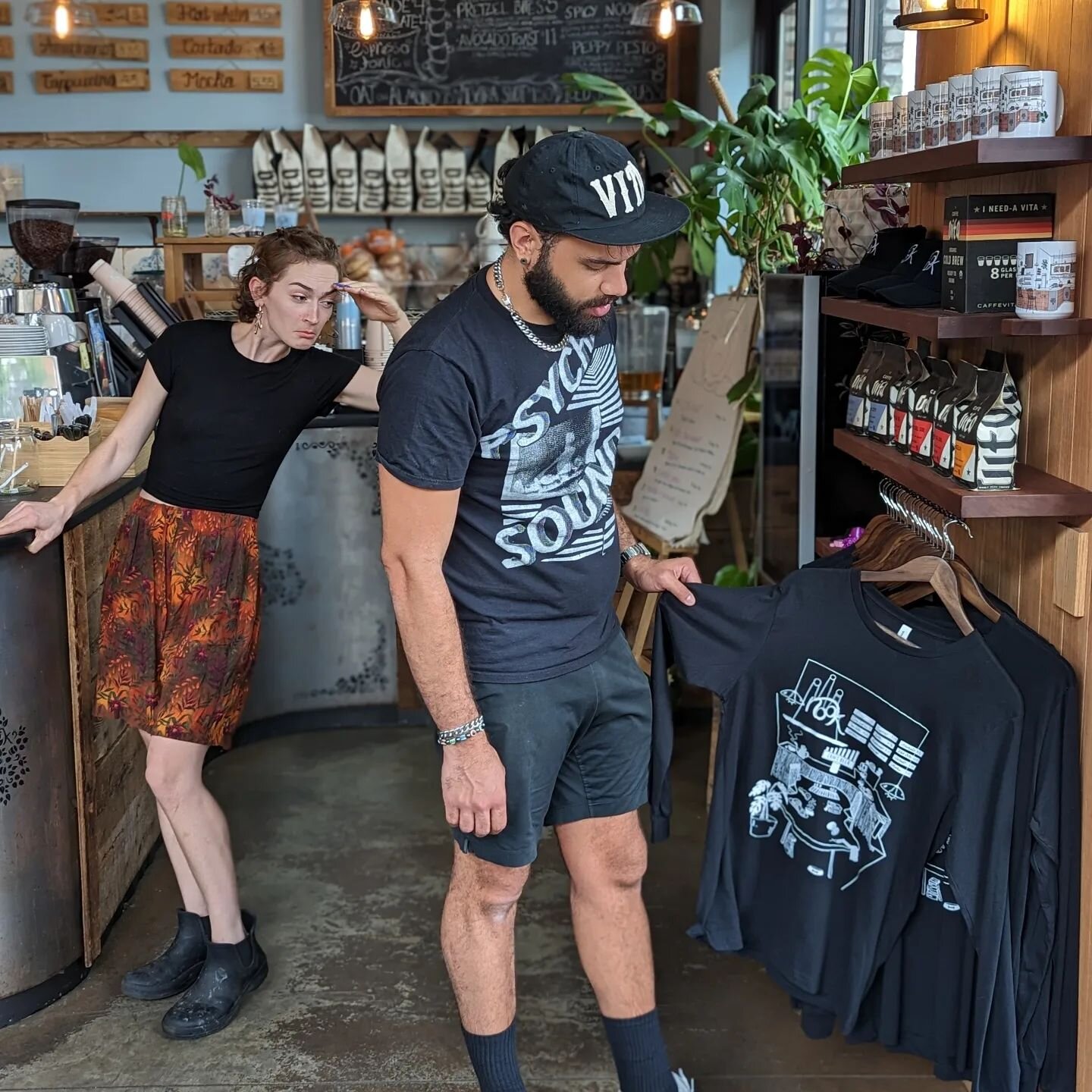 📸 Drama Unfolds at the Counter 🎭

Scene 1: Barista Soli curiously eyes the newly coveted Nook shirts in the distance. Meanwhile, Barista Joel gazes in wonderment as he sets his sights on the sleek, comfy black long-sleeve shirt, longing to liberate