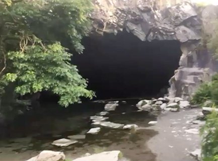 Stepping stones lead into the pool of water that fills this cave made by slate mining.