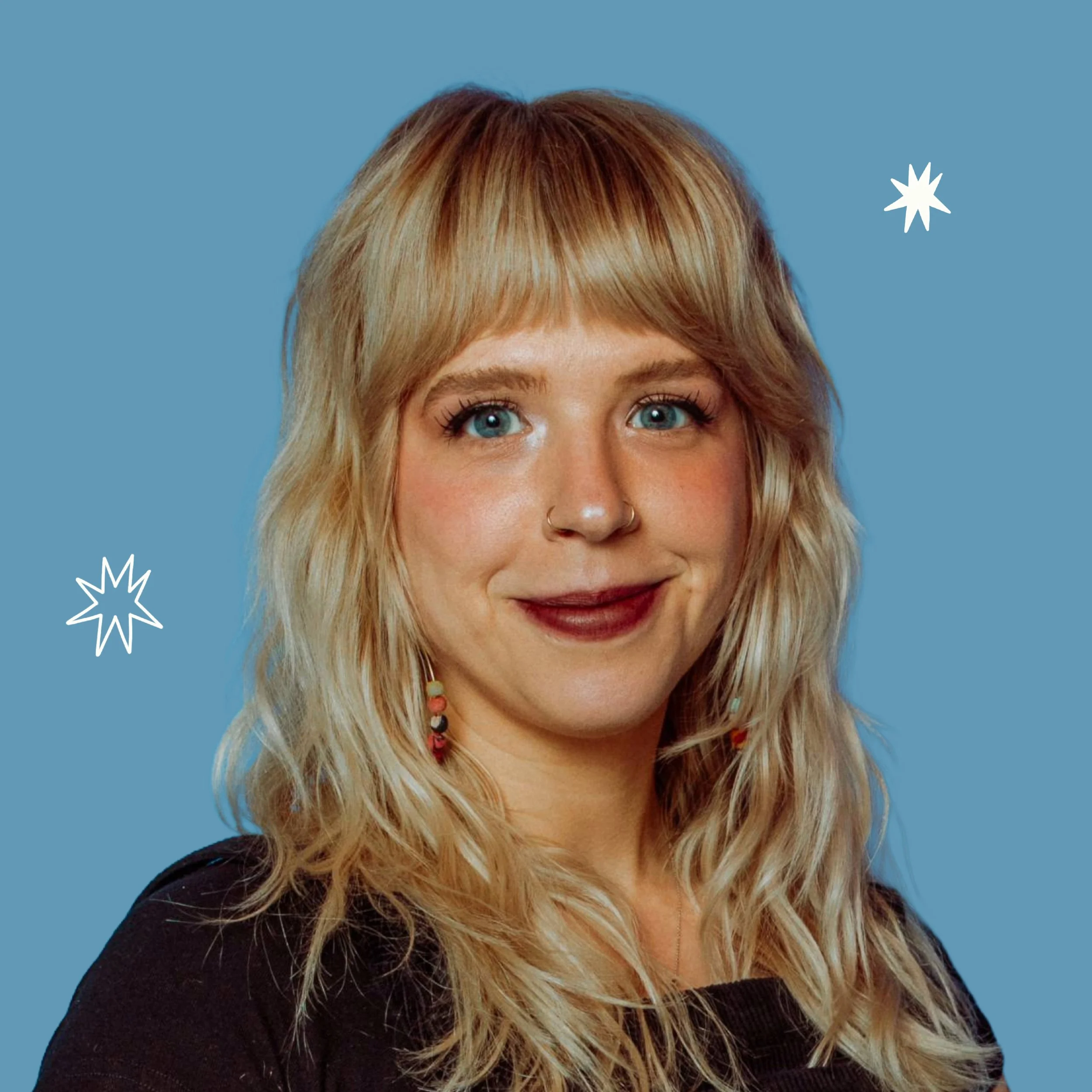 Close-up of a woman with blonde hair, blue eyes, wearing makeup, earrings, and a nose ring, against a blue background with white star illustrations.