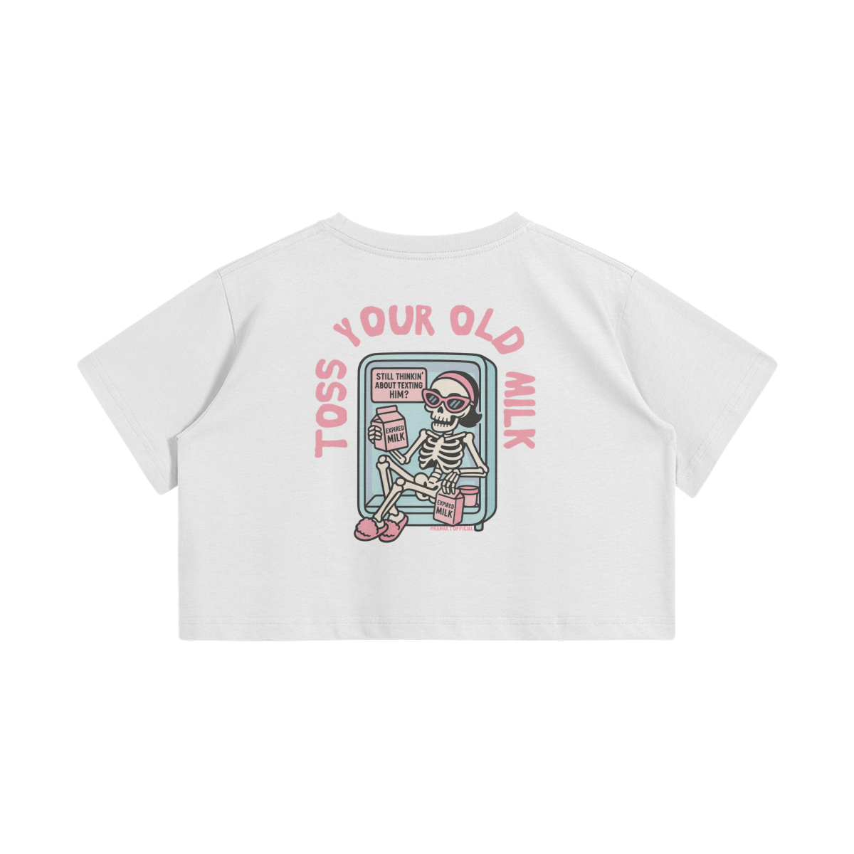 White crop top with a cartoon skeleton lounging in a fridge holding expired milk. Pink text says “Toss Your Old Milk” above the illustration.