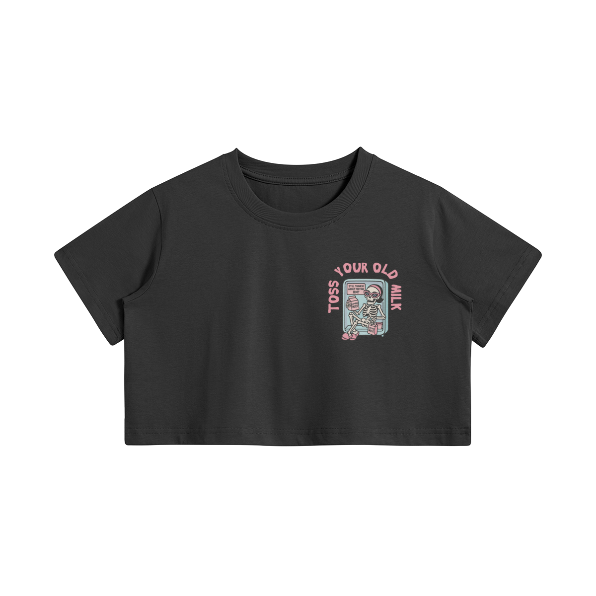 Black crop top with a cartoon skeleton lounging in a fridge holding expired milk. Pink text says “Toss Your Old Milk” above the illustration.
