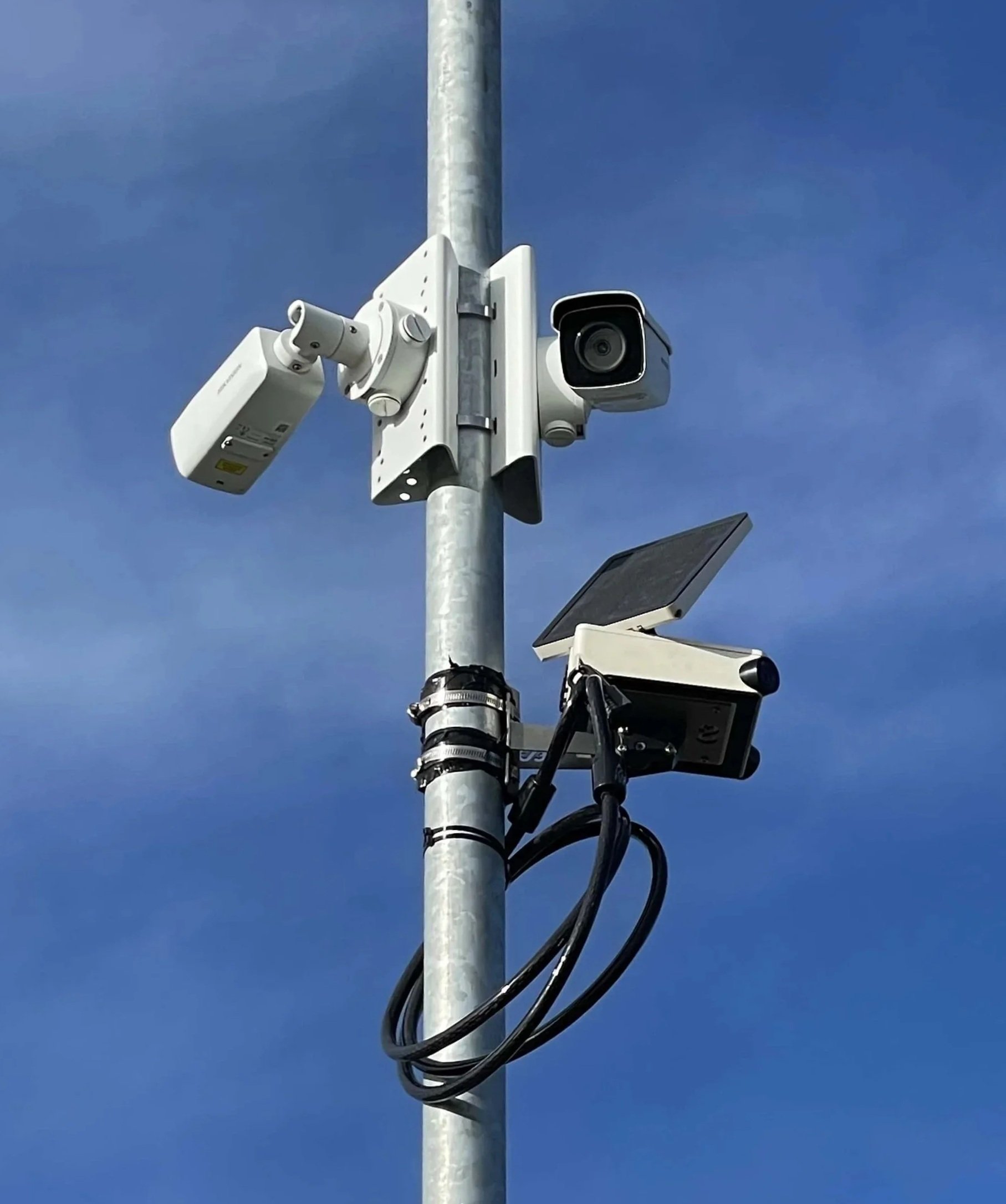 Mounted construction site cameras and a solar-powered time-lapse camera system used for project progress monitoring and visual documentation.