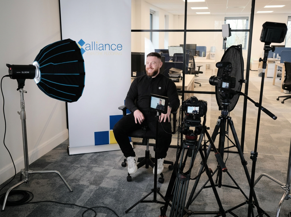 A man sitting in front of two camera smiling, he's being interviewed.