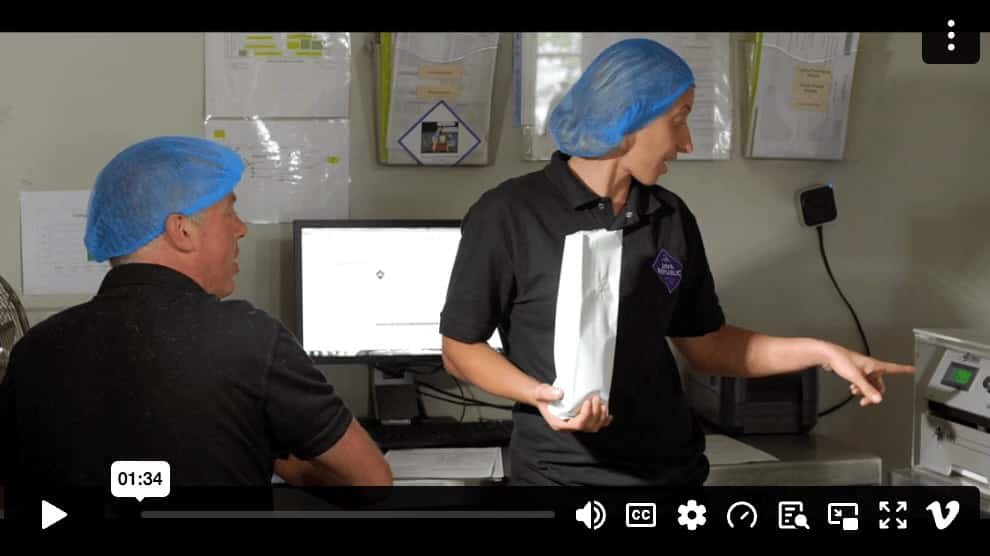 Two Java Republic roasters discussing coffee weight during the roasting process