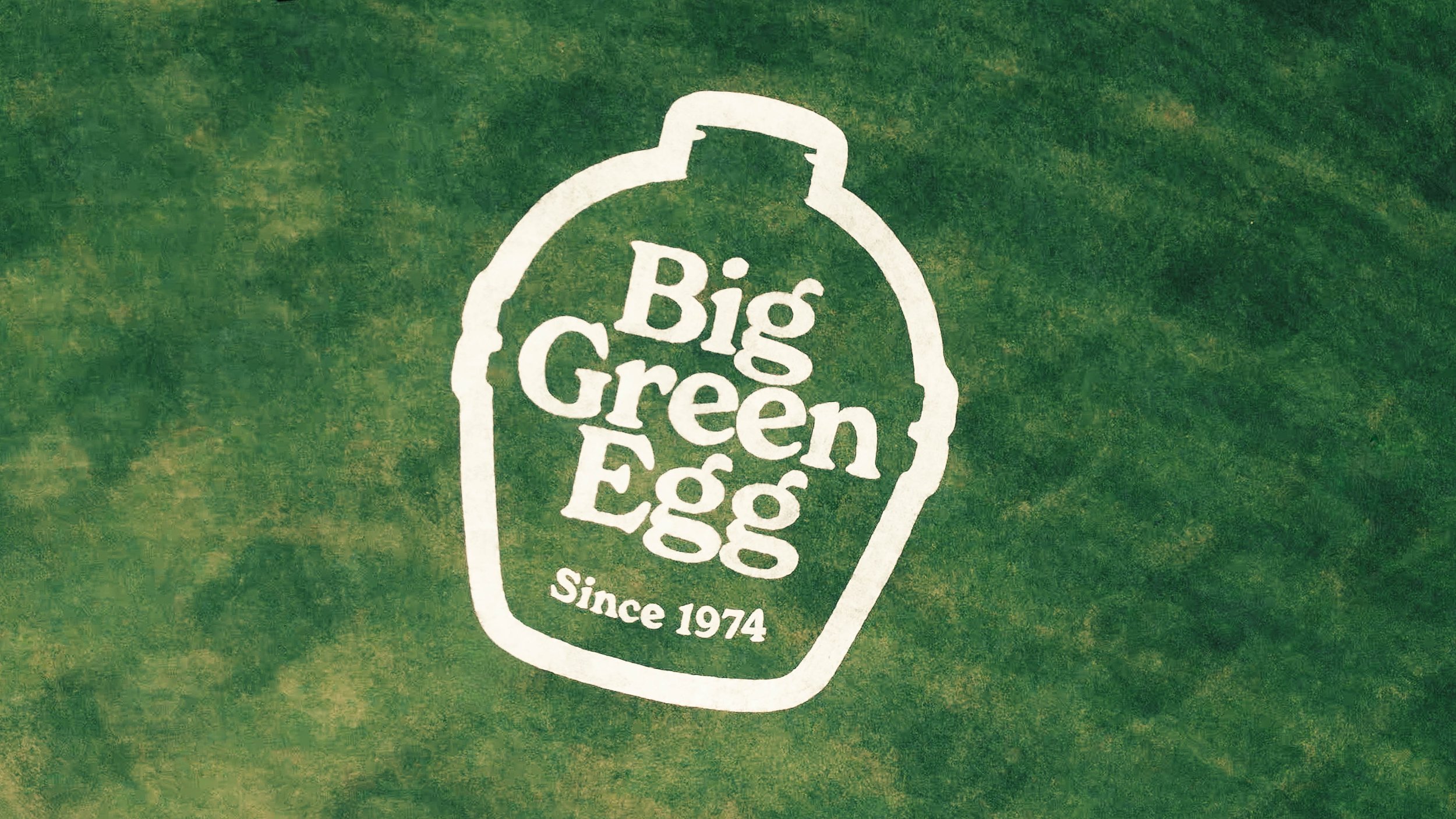 Logo of Big Green Egg on a green background featuring an outline of the egg-shaped grill and the text 'Big Green Egg Since 1974'.