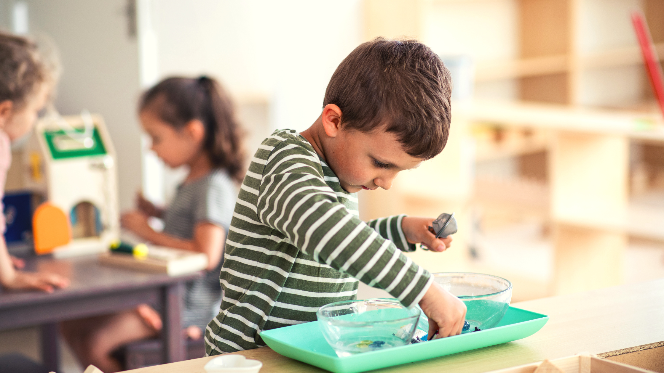 Child engaged in a Montessori practical life activity using water and tools, developing fine motor skills and concentration.
